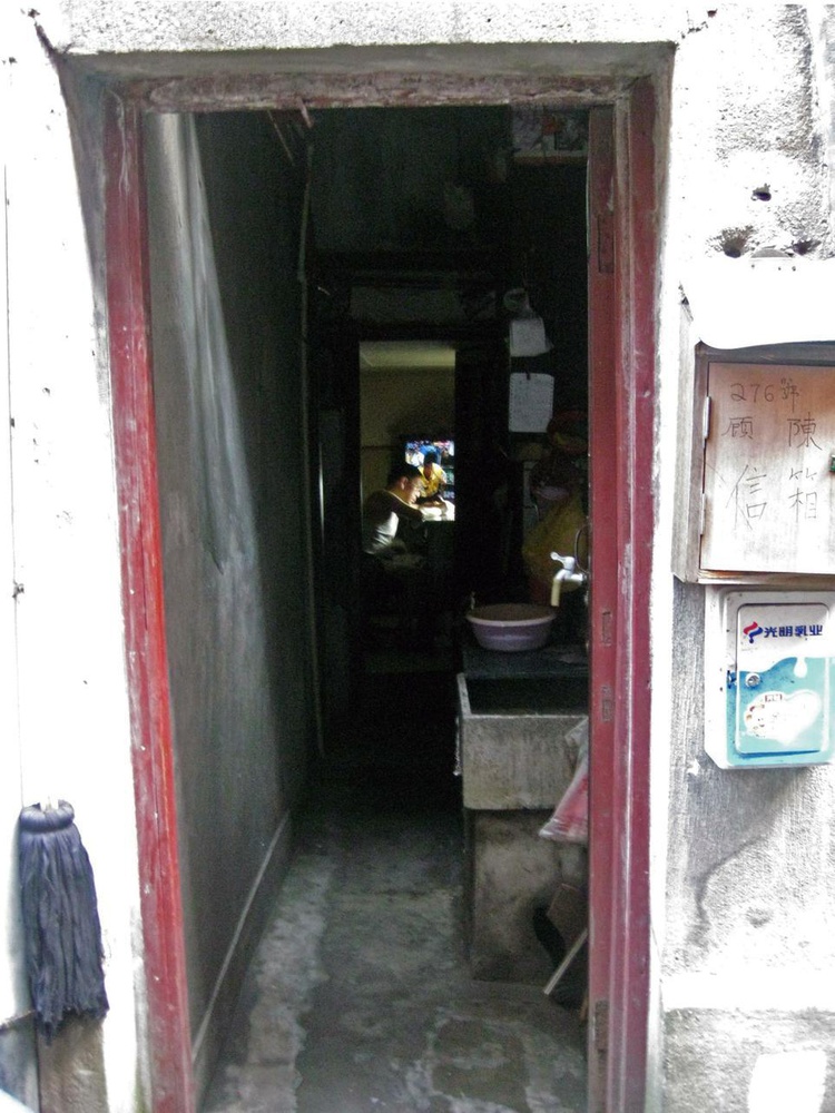 Inside an old Shanghai one-story apartment with peeling paint and rusted pipes, a man does work while watching a popular replay of the NBA final. The area around his home, Tianzi Fang, has preserved its antique charm despite its residents leasing spaces for restaurants, boutiques, and cafes that bring both local and tourist foot traffic.