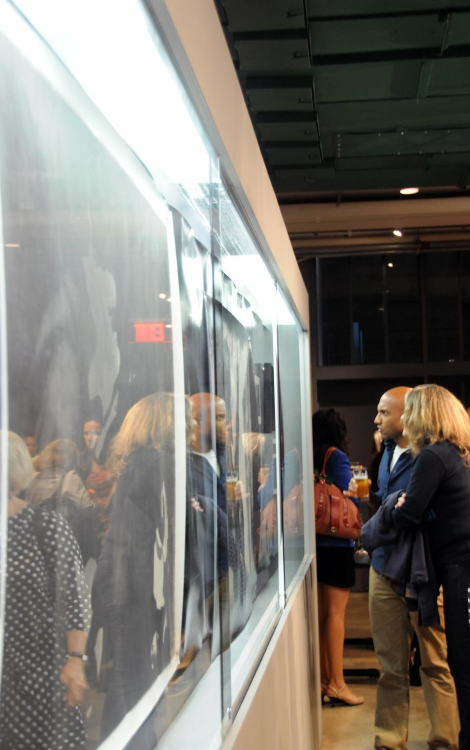 Guests attend the opening reception of Matt Saunder's Exhibition: 'The movies that were secret remain secret somehow and a nation forgets its pleasures." in the Carpenter Center