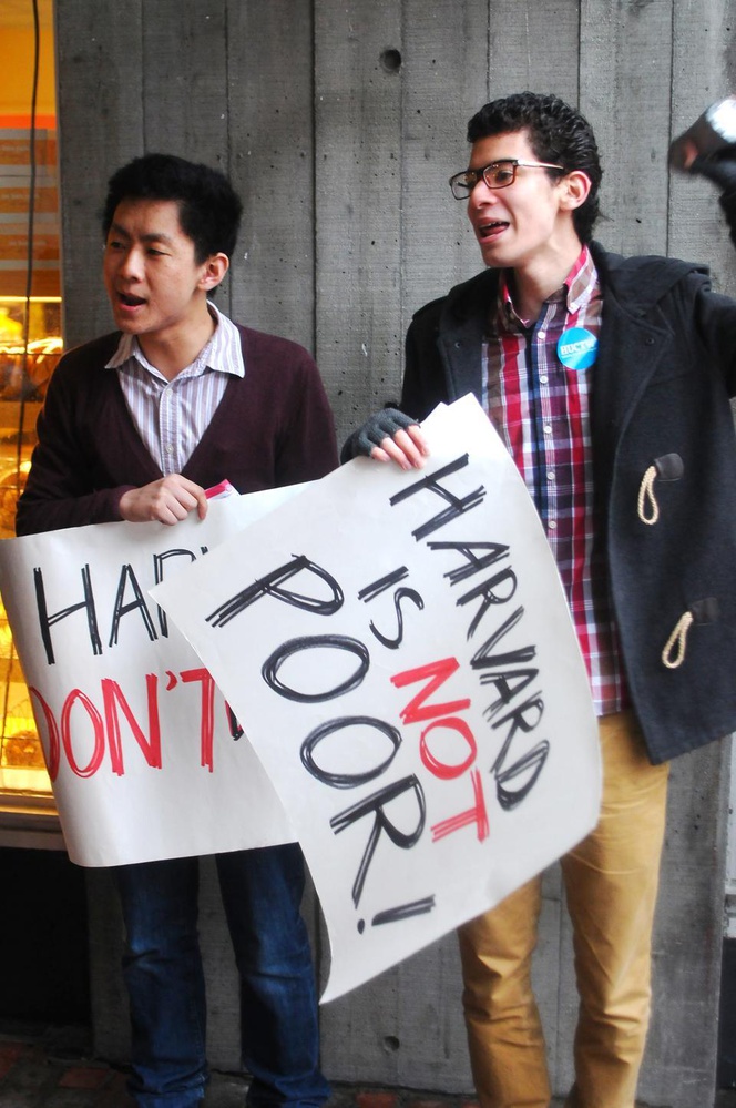 Alex L. Chen '16 and Gabriel H. Bayard '15, members of the Student Labor Action Movement, protest layoffs in University Financial Services outside the Holyoke Centre on Tuesday.