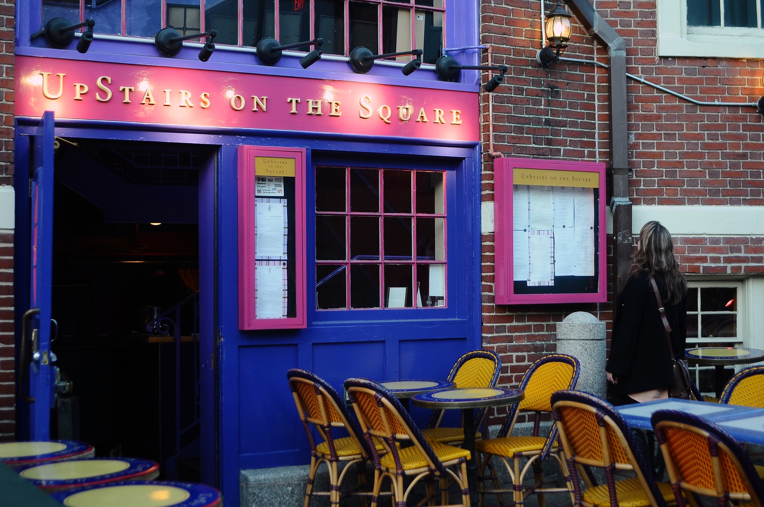 A woman scans the menu at Upstairs on the Square on Winthrop St. The upscale bar and restaurant, which has occupied its current location since 2002, will close its doors at the end of the year.