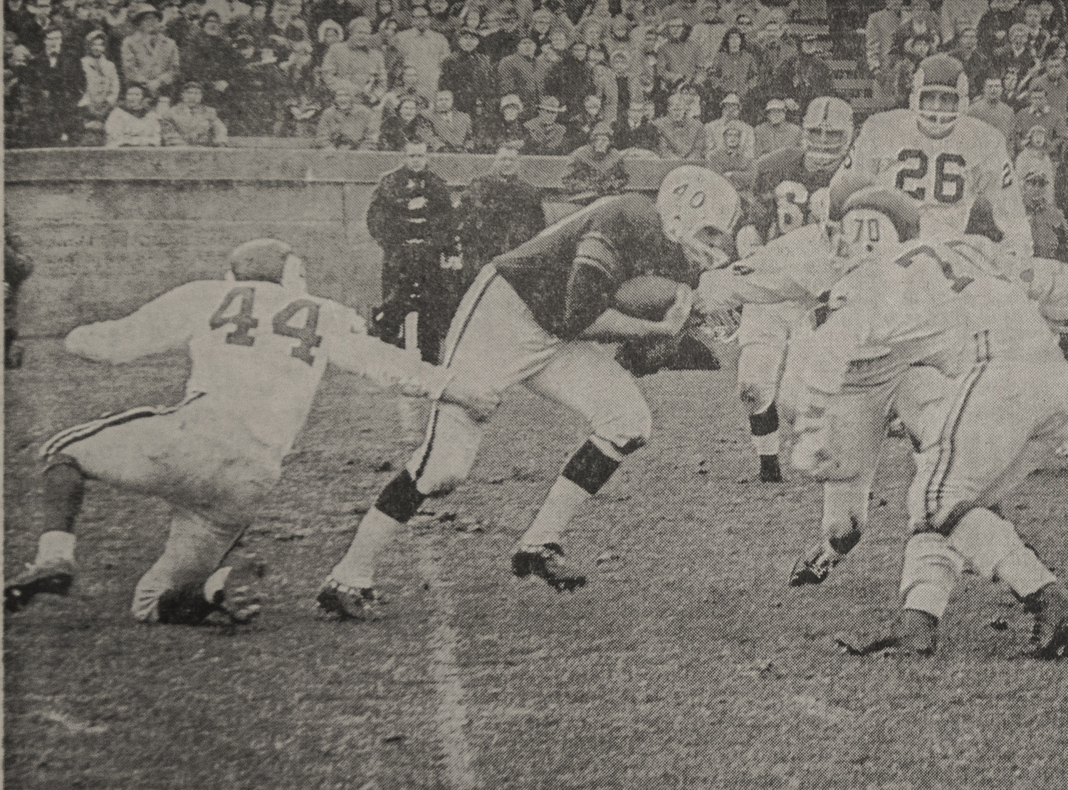 Yale's Bill Henderson (40) runs into Crimson opposition during the second period of the 1963 Harvard-Yale Game, as John Dockerty (44), Jack Neuenschwander (70), and Rick Beizer (26) converge on the Eli halfback. This photograph from the New Haven Game, which was rescheduled for November 30 after the Kennedy assassination, ran on the third page of the Monday, December 2, 1963, issue of The Crimson.
