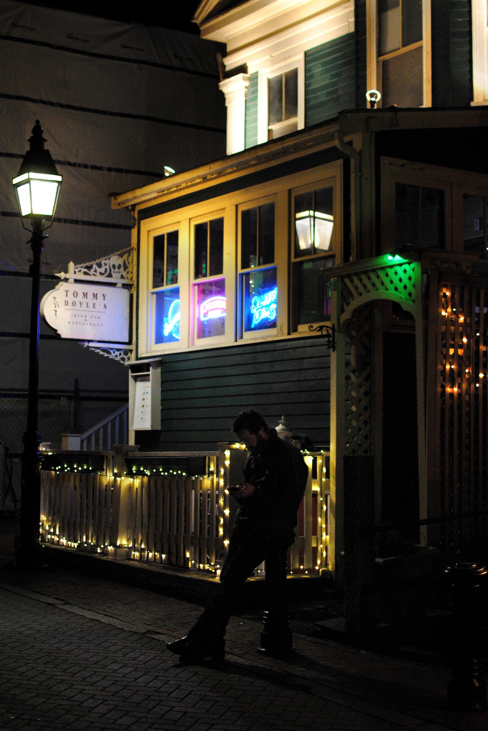 A man stands outside Harvard Square’s classic pub, Tommy Doyle’s, on Sunday night. The central location of Tommy Doyle’s to Harvard’s campus has made it a popular spot for students, but the business will close by the end of December.