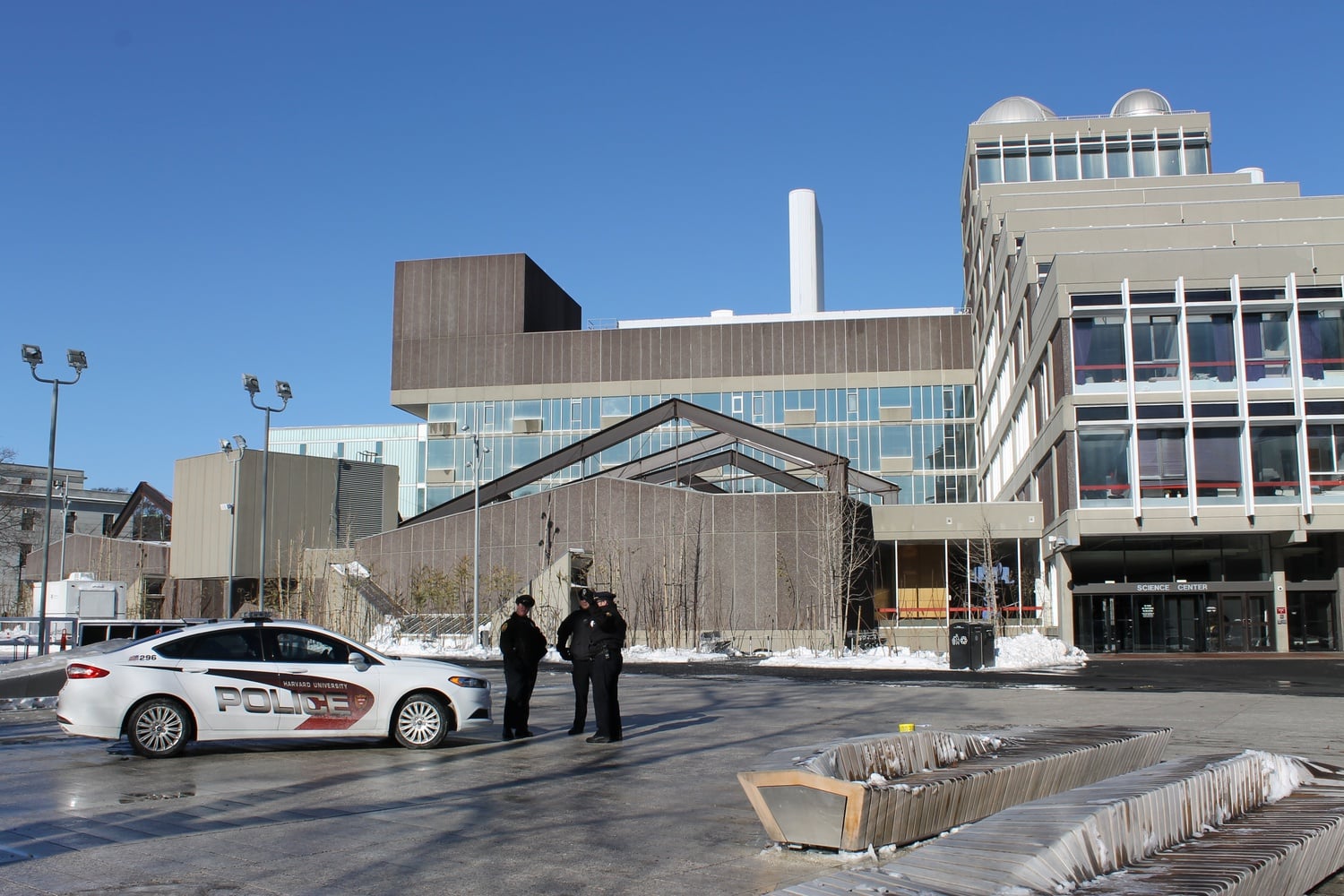 Harvard University Police Department officers congregate outside the Science Center, one of the four sites evacuated after HUPD received unconfirmed reports of explosives earlier this morning.