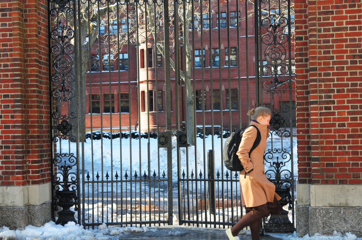 A student walks by Sever Gate after Harvard Yard had been closed Monday afternoon. The University locked down the Yard after reports of explosives in four Harvard buildings.