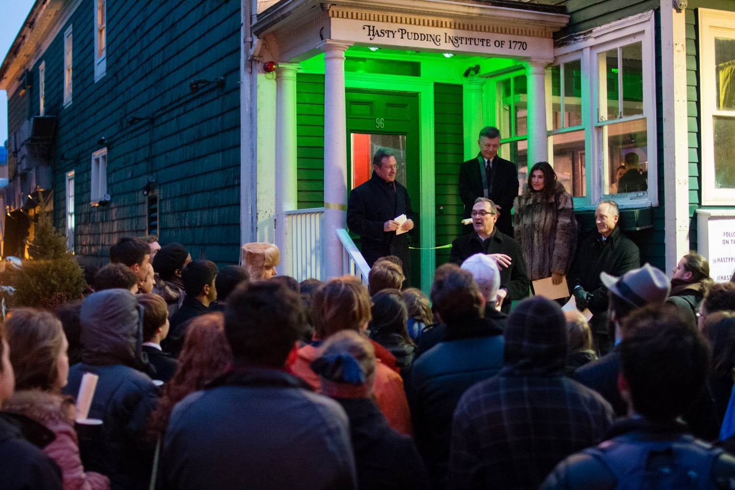 Flanked by Andrew L. Farkas '82 and Dean of the Faculty of Arts and Sciences Michael D. Smith, Cambridge Mayor David P. Maher presides over a ribbon cutting for the clubhouse of the Hasty Pudding Institute of 1770.