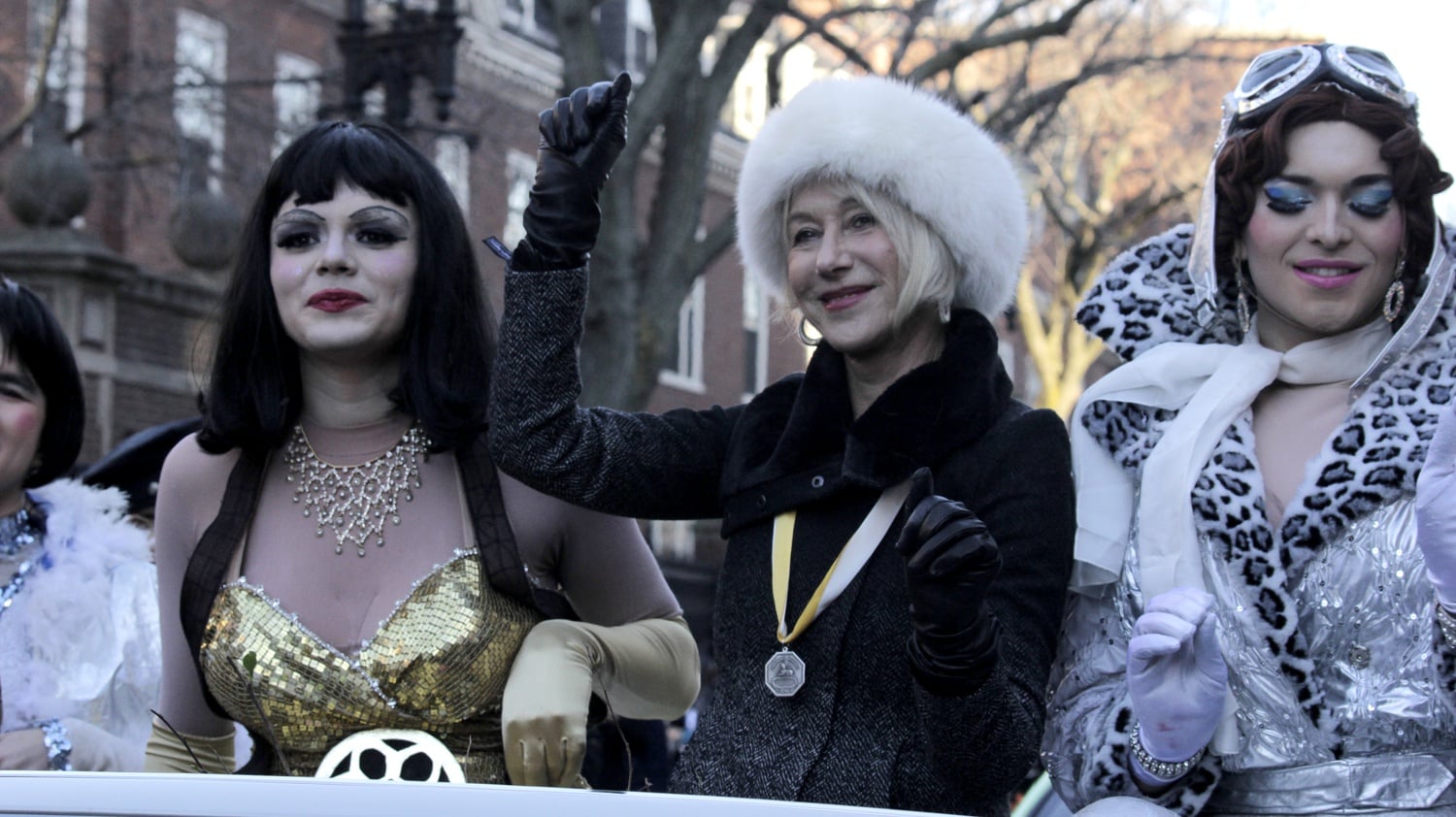 Helen Mirren snaps during the Hasty Pudding Theatricals' Woman of the Year Parade down Massachusetts Ave. on Thursday afternoon. The troupe honored her as its Woman of the Year.