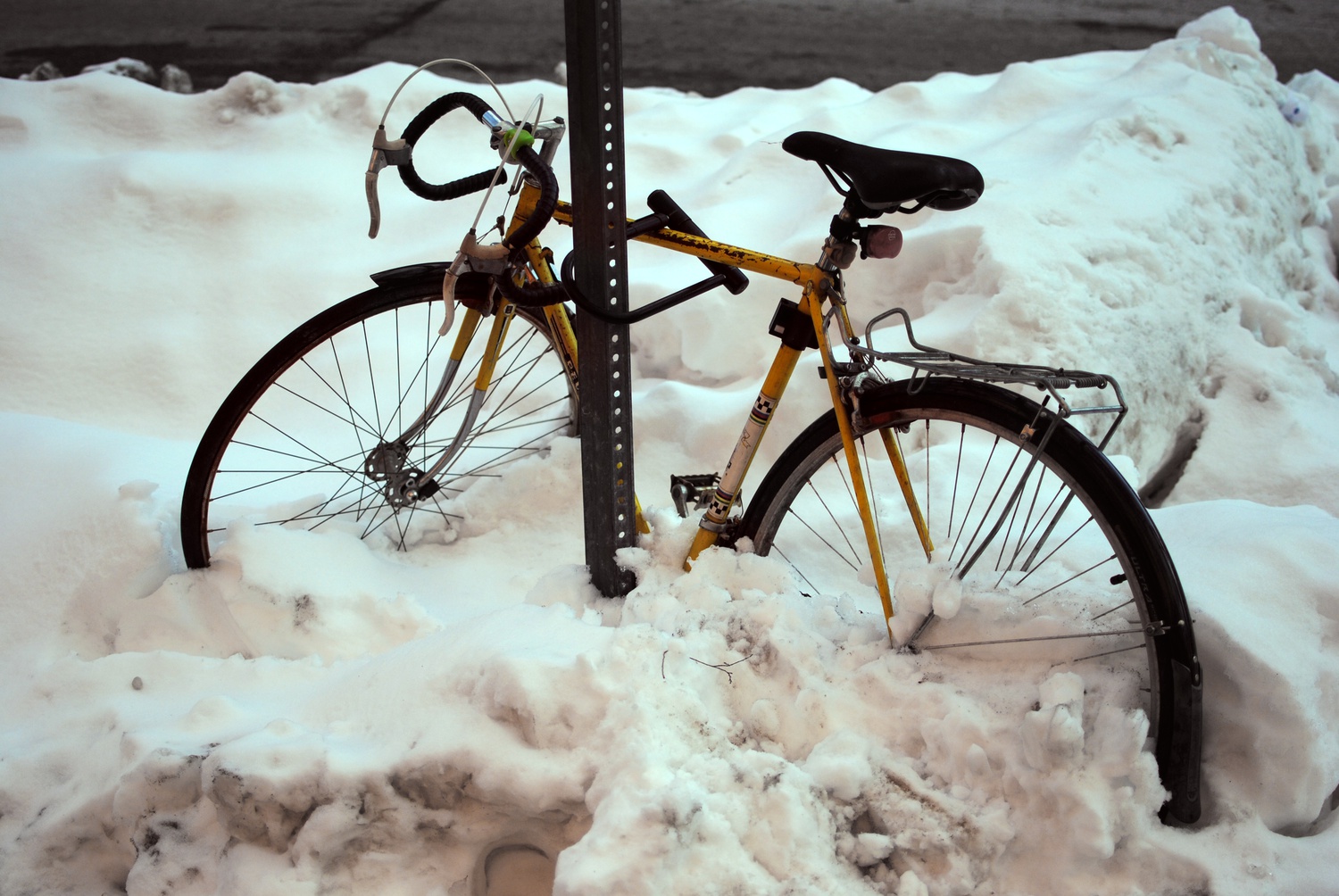 A bike sits half submerged in Harvard Square on Feb 10. Although most roads in Cambridge have been cleared of snow, it still poses a challenge around Harvard's campus.