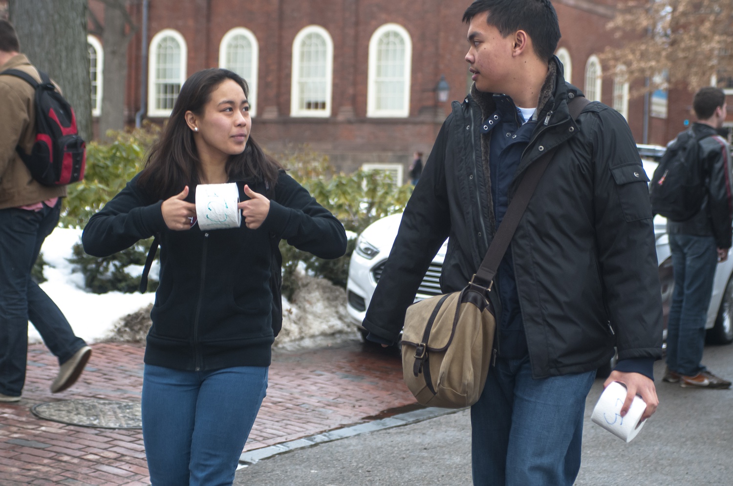 Shori Hijikata '16  and Mark M. Natividad '16 hold toilet paper thrown by Undergraduate Council president Gus A. Mayopoulos '15 and UC Vice President Sietse K. Goffard '15 after a rally held in front of Massachusetts Hall on Thursday, Feb. 20.