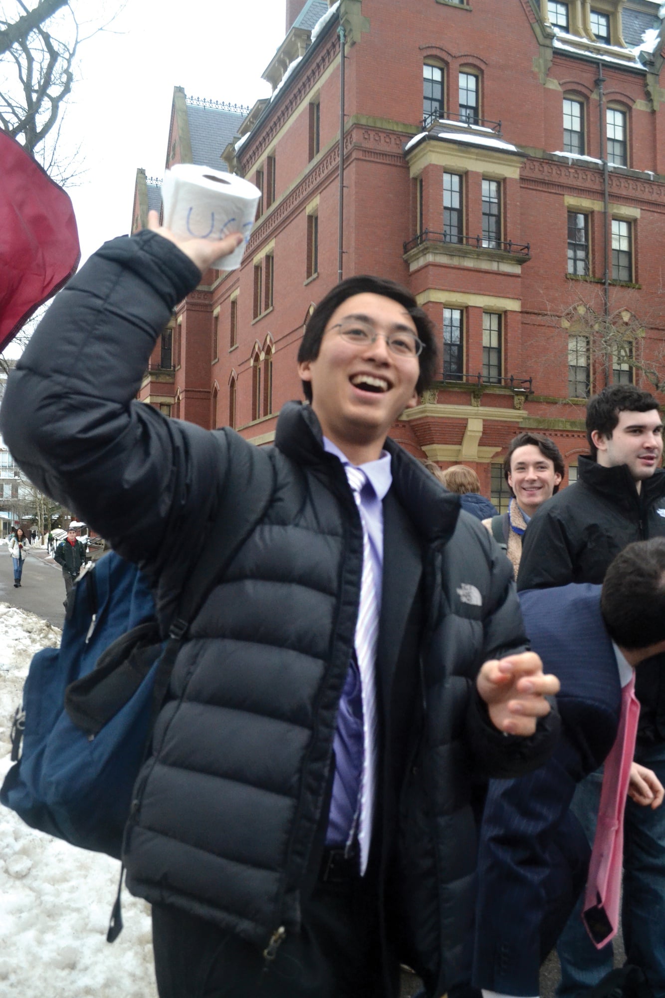 Undergraduate Council Vice President Sietse K. Goffard '15 throws toilet paper to a crowd of students during an organized rally to ask the university for increased funding. 