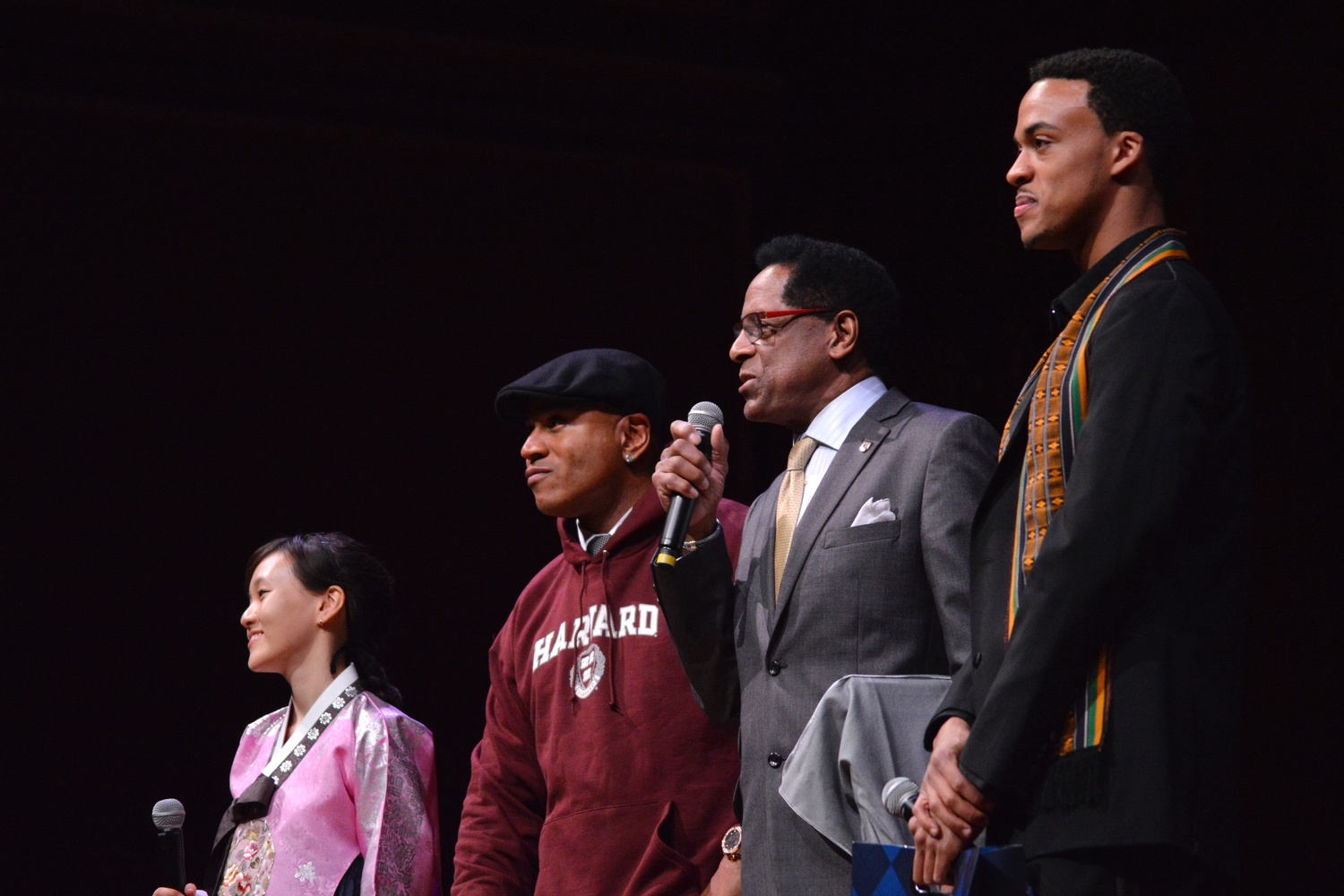 LL Cool J, the Harvard Foundation's Artist of the Year, dons a Harvard hoodie as Foundation Director S. Allen Counter presents an official plaque. Soyoung Kim '14, left, and Aubrey J. Walker '15, right, directed the festival.