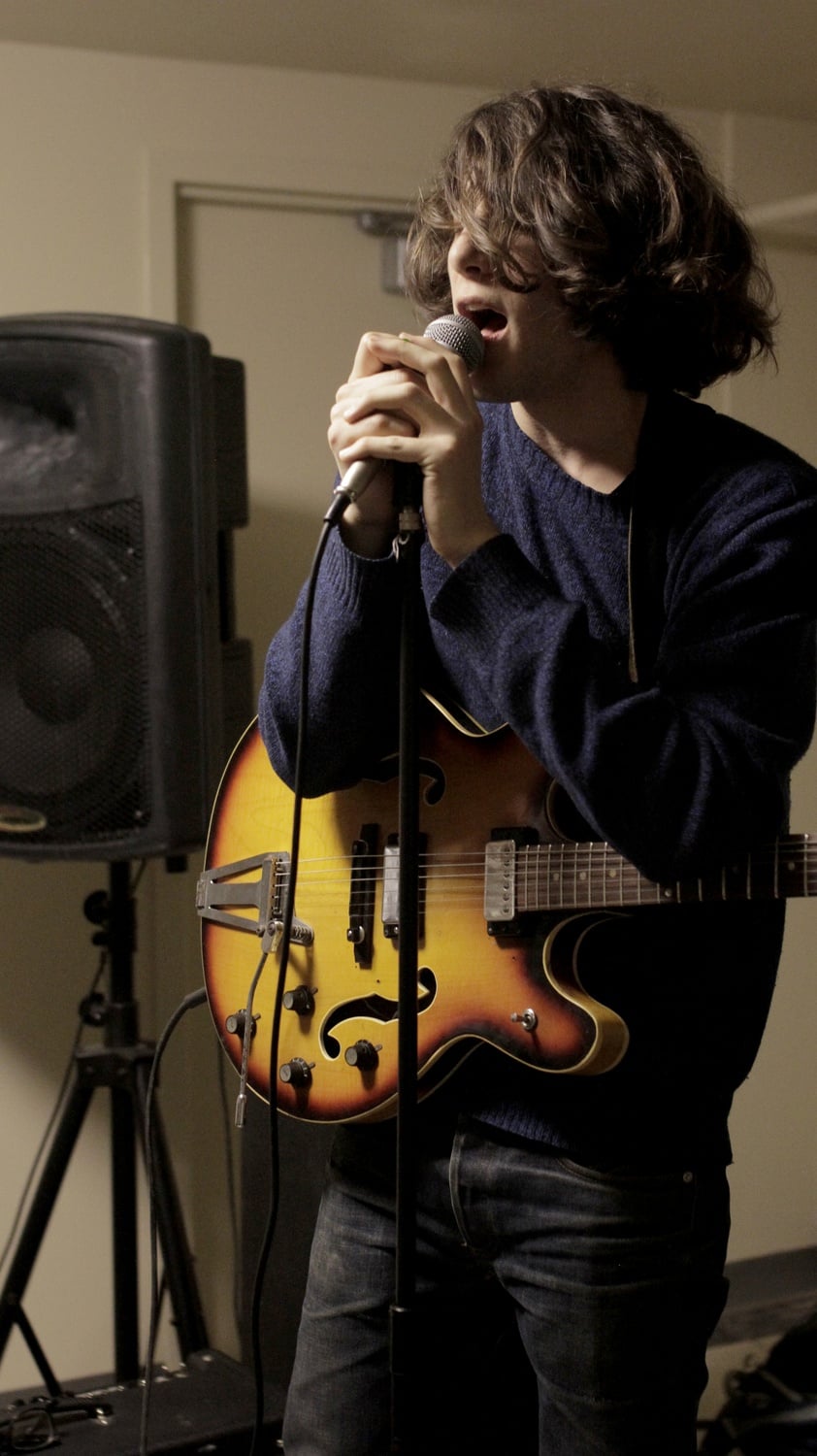 Nicolas J. Schwalbe '14 of L.A. Jeff sings during band practice in the Lowell House basement.