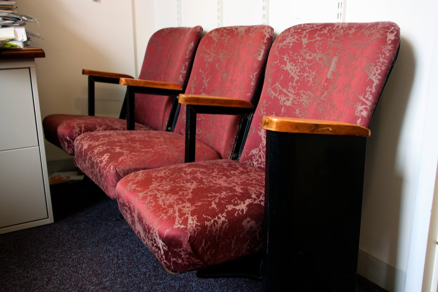 Movie theater seats previously used in the Somerville Theatre during the 20th century are permanently affixed to the floor.