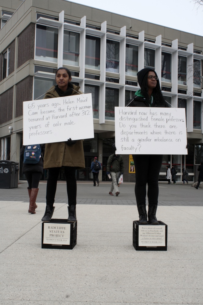 Ceylon Auguste-Nelson '16 and Mariah T. Browne '15 pose as statues in front of the Science Center on Tuesday afternoon. As part of Women's Week 2014, the goal was to promote discussion about the role of gender at Harvard.