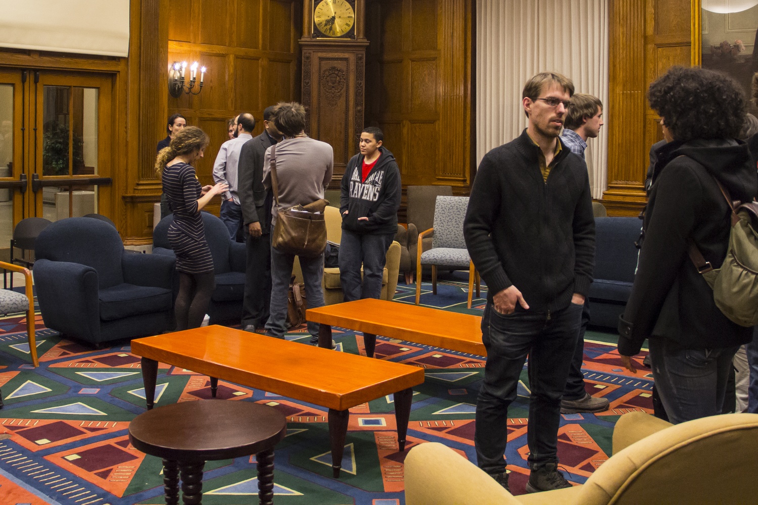 Graduate students chat after a town hall meeting about the teaching fellows system in March. Students cited late paychecks, large section sizes, and teaching appointments as problems with the current system.