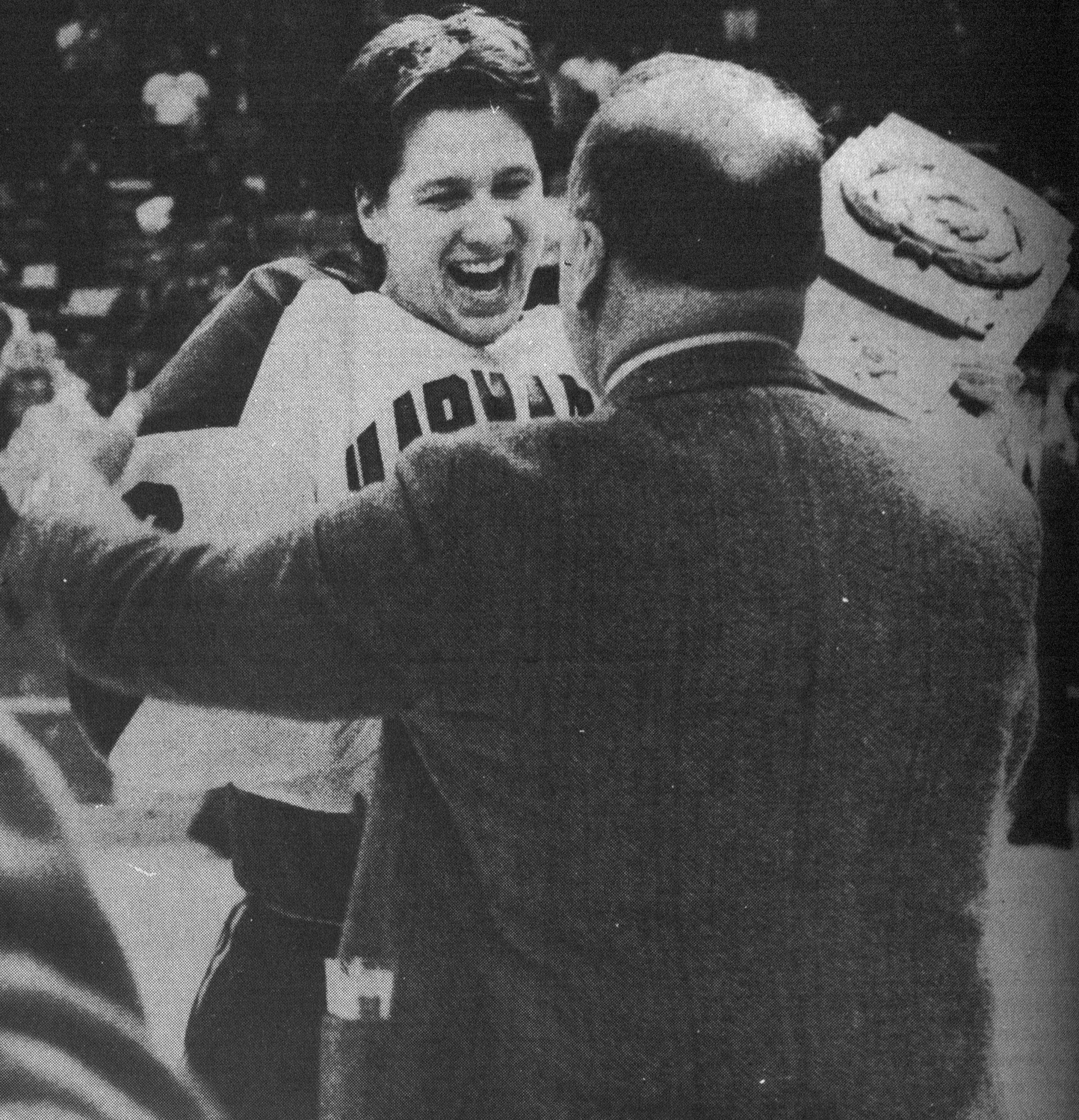 NCAA trophy in hand, Harvard captain Lane MacDonald ’88-89 (left) embraces coach Bill Cleary ’56 on the ice following Krayer’s goal. MacDonald would accept the Hobey Baker Award in St. Paul the next day.