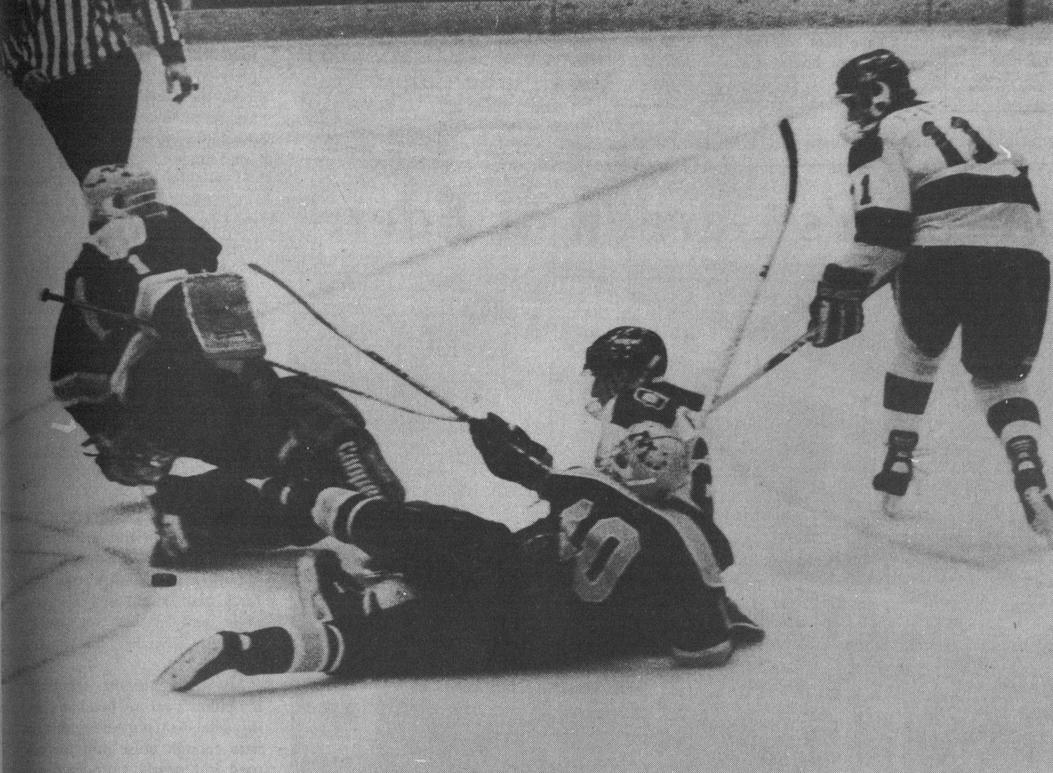 Ed Krayer ’89-90 (right) watches his championship-clinching shot slide past teammate John Weisbrod ’91 and senior Minnesota goaltender Robb Stauber in overtime.