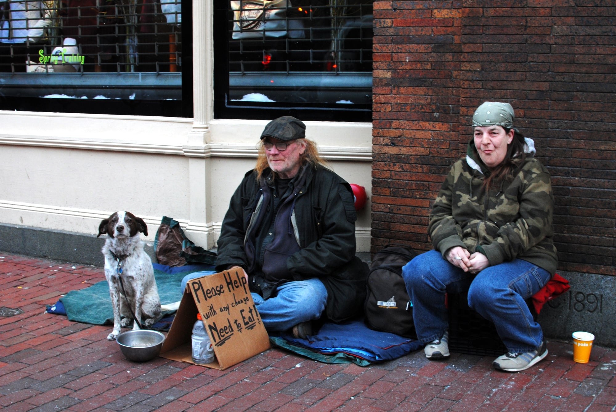 Ken, left, and Frenchie, right, ask for spare change with their dog Penny outside clothier J. August. Ken ran an outdoor book store on the sidewalk of Massachusetts Ave. for eight years before having to shut down in 2013. 