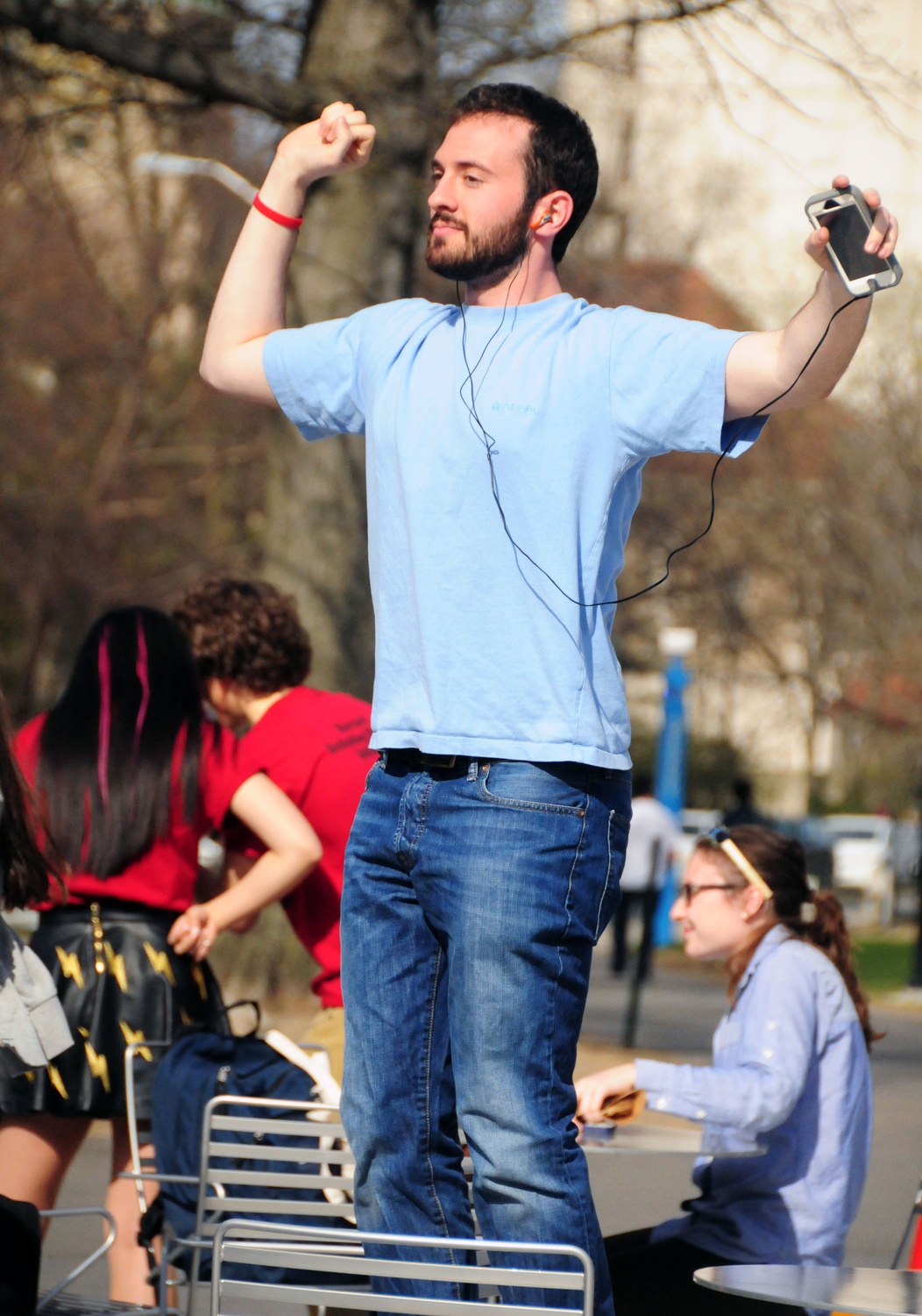 Harvard Undergraduate Council president Gus Mayopoulos '15 listens to an audio recording that tells participants what to do during the flash mob for Mob Malaria. 