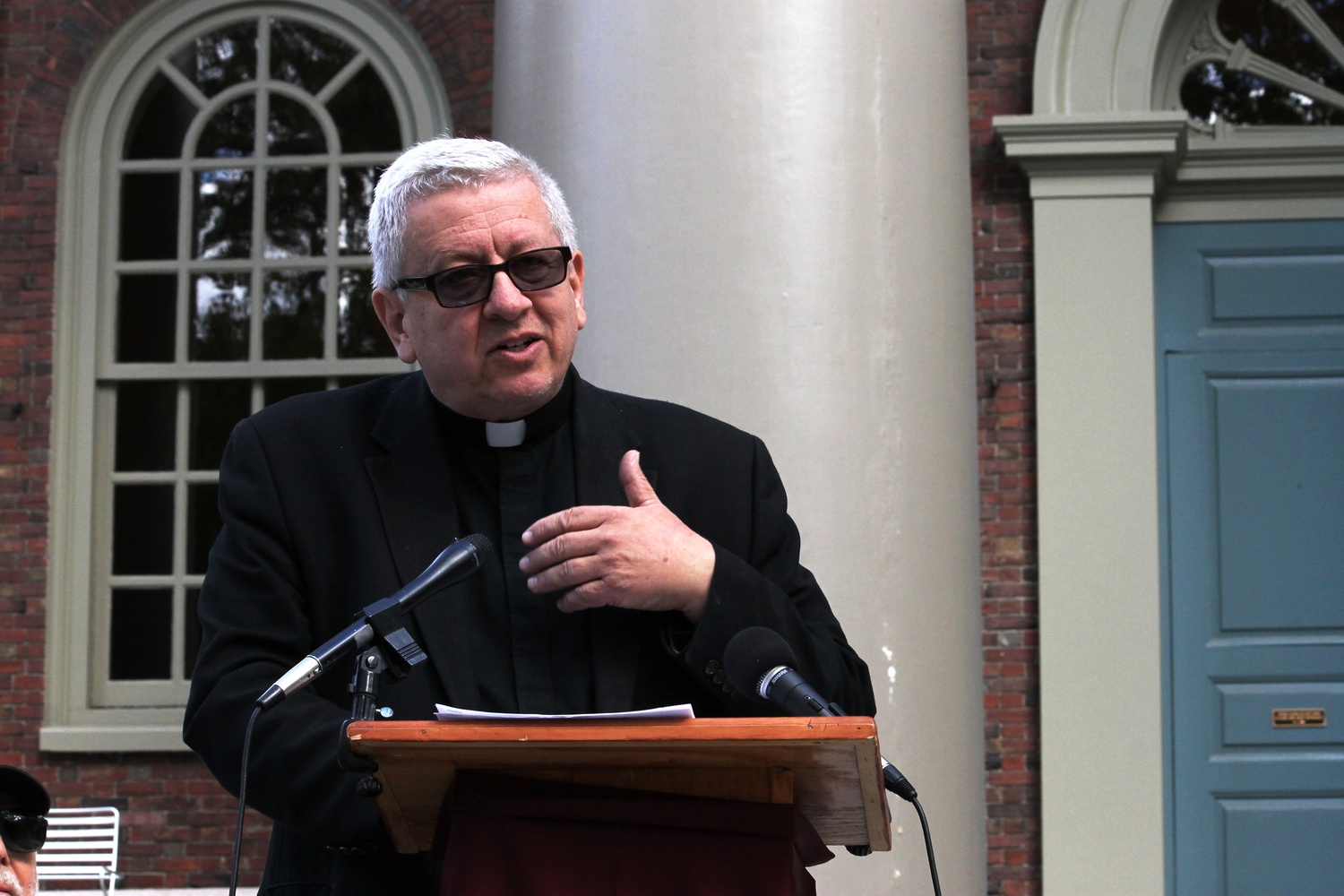 Father George Szal addresses the media alongside professors and clergy on the casino repeal effort on Monday morning on the steps of Memorial Church. 