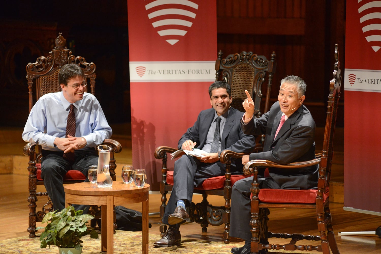 Dean of the College Rakesh Kurana, center, mediates the discussion between Micheal J. Puett, left, and Charles M. C. Lee, right, about the American Dream in Sanders Theatre on Saturday.