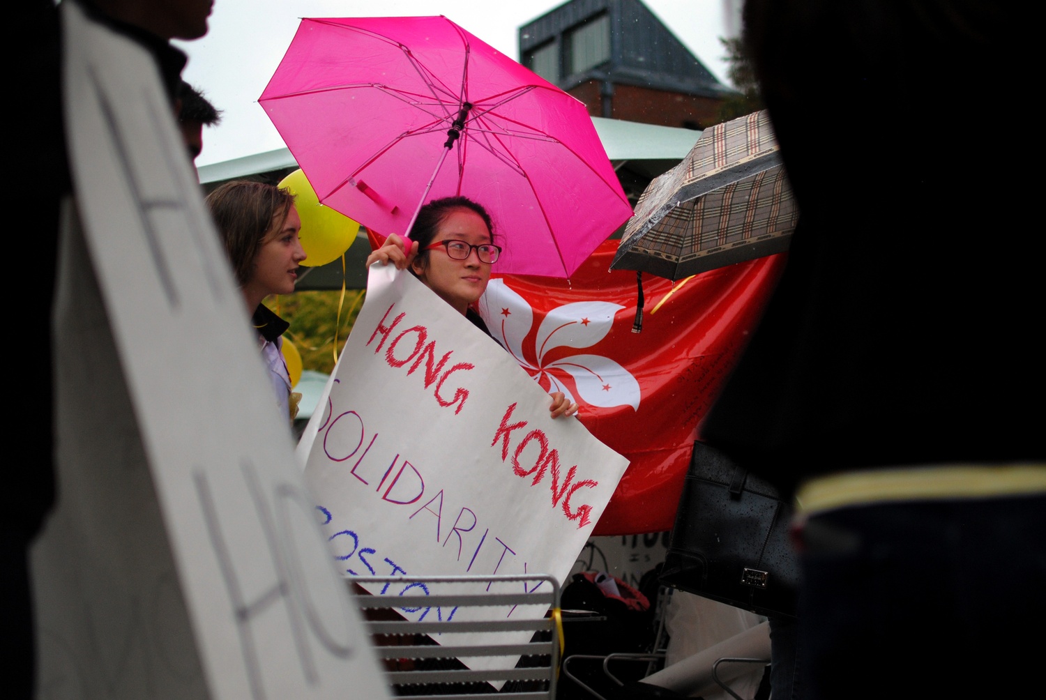 Dora, a former Harvard Summer School Student, shows support for Hong Kong freedom advocates that have experienced violence and repression in the past week. The group of students that came together braved the rain and passed out yellow ribbons as a symbol of their support on Wednesday in the Science Center Plaza. 