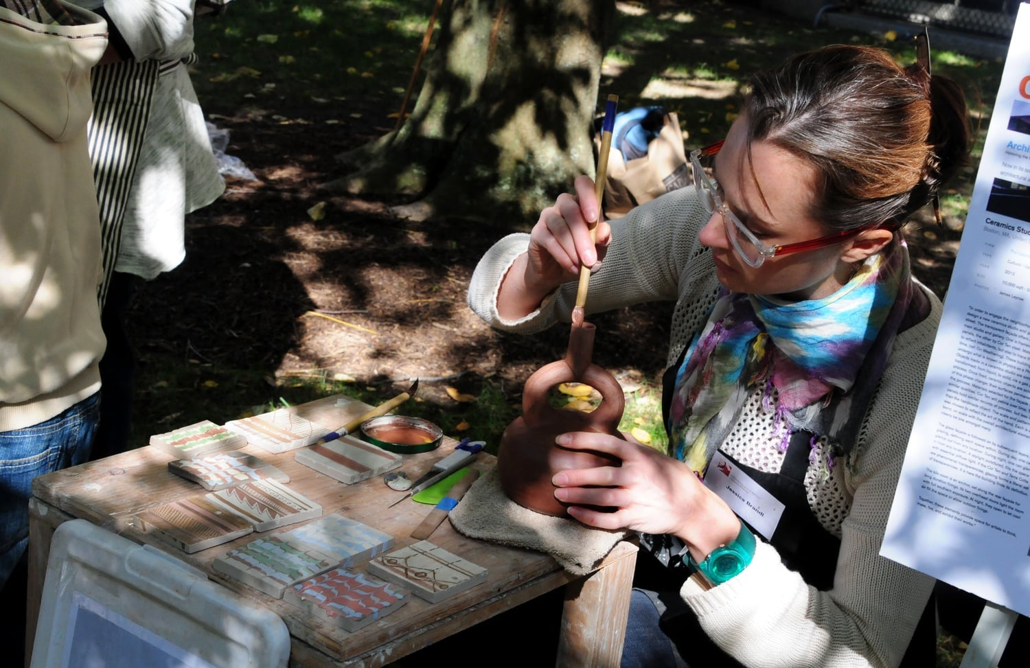 OFA Artist-in-Residence Jessica A. Brandl touches up a clay vessel at the archaeology fair was held by the Peabody Museum and the Semitic Museum on Oct. 5.