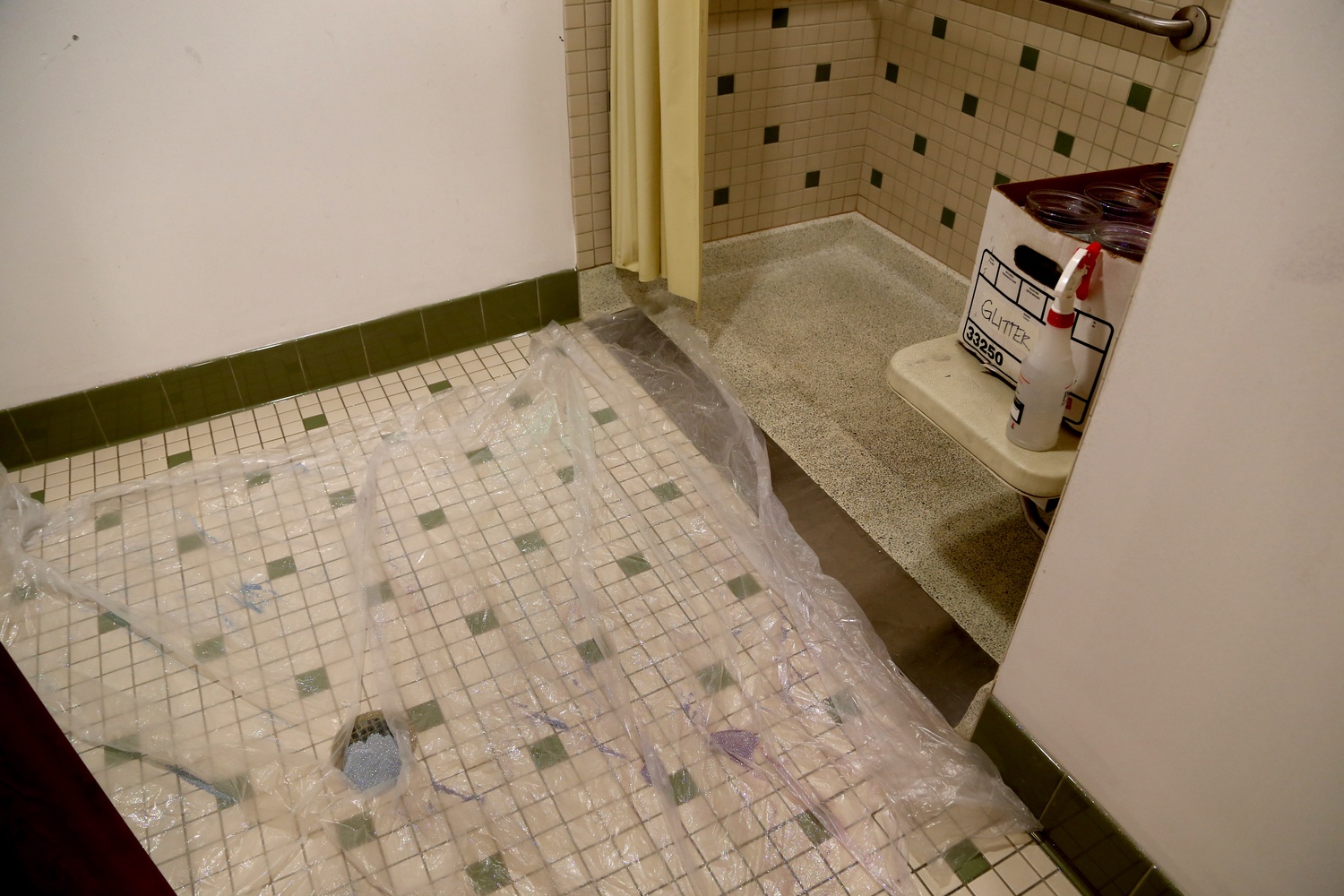 Castmembers stand on the plastic as they shower themselves with glitter inside the "Glitter Room" at the Oberon.