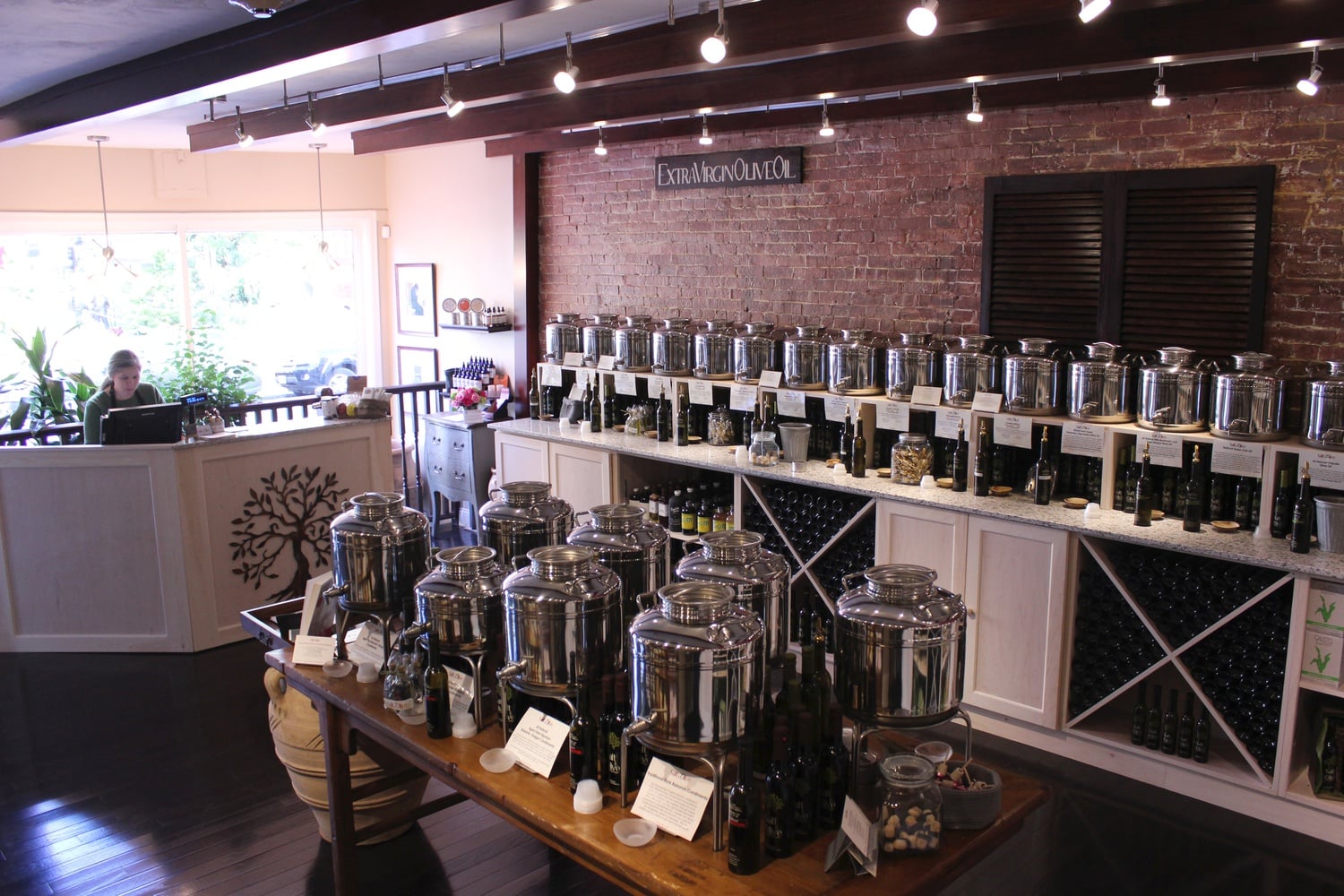 Containers filled with oil and vinegar sit behind a row of samples at Salt & Olive. Bread for dipping and water are offered free of charge to customers.