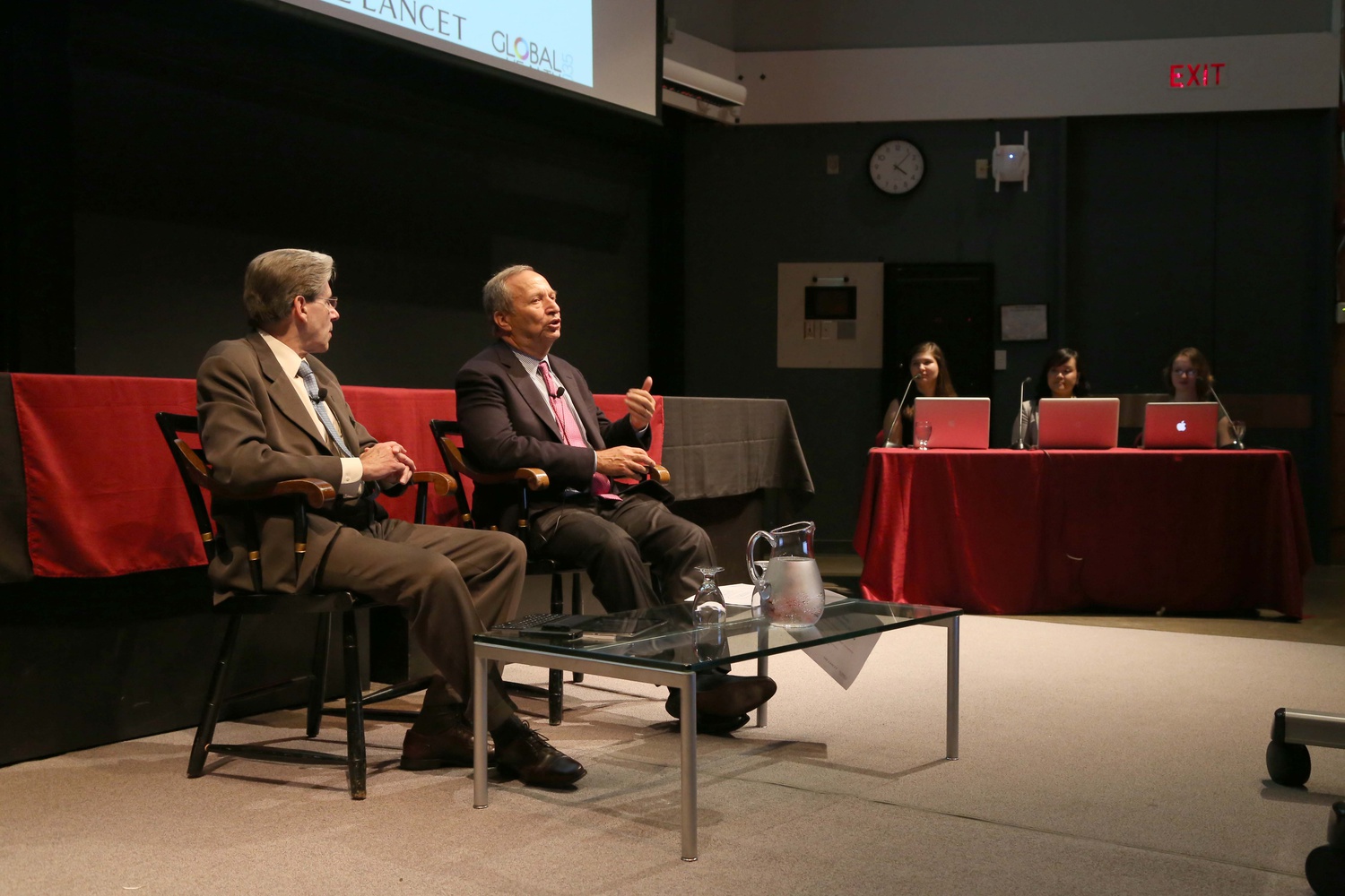Dean of the Harvard School of Public Health Julio Frenk, left, listens as former University President Lawrence H. Summers, center, speaks about global health during a discussion on the topic in the Science Center on Tuesday afternoon. 