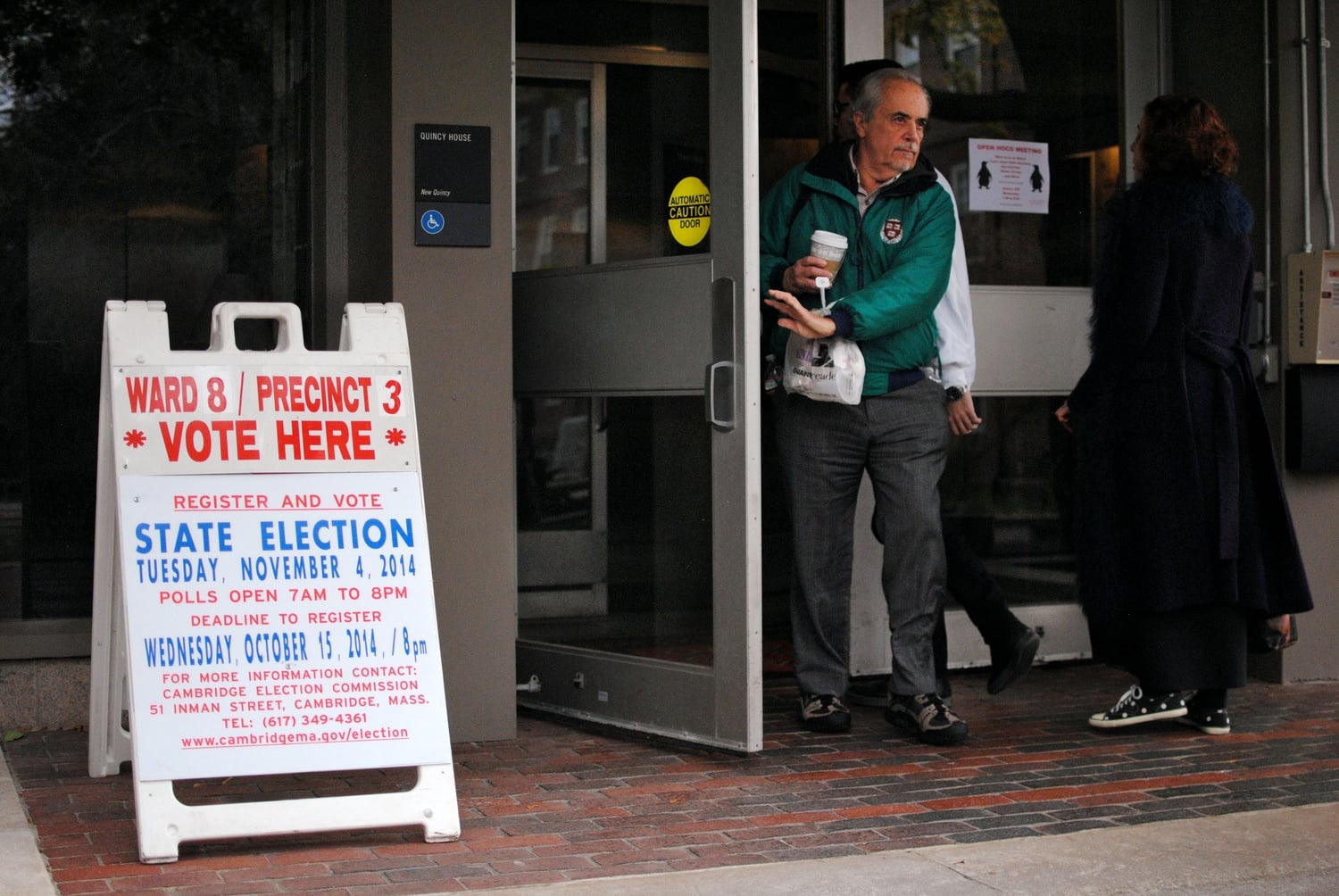 Members of the Harvard-Cambridge community come and go at the polling station in the lobby of Quincy House Tuesday afternoon. 