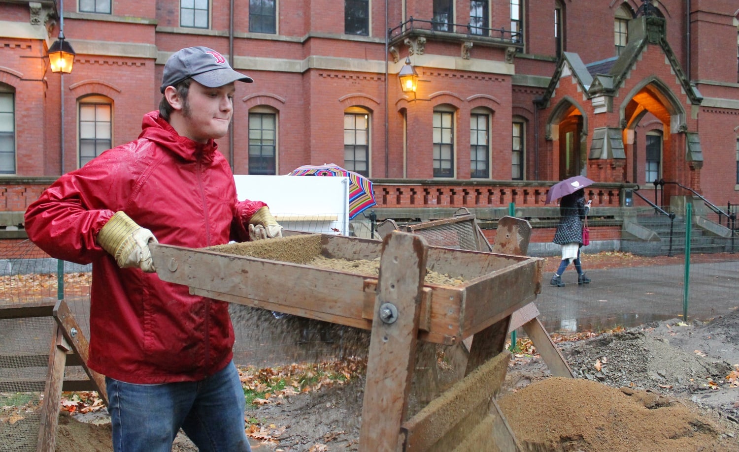 A student sifts through excavation finds of the predicted site of the Indian College on Thursday at the results day outside of Matthews Hall. 