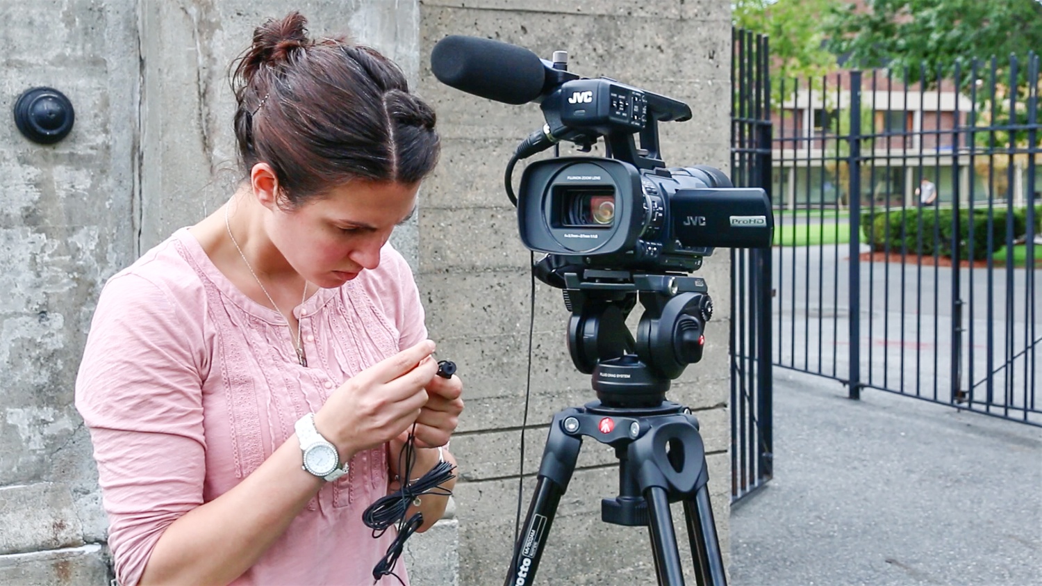 Assistant Director of Athletic Communications Alli Miller prepares a camera for the football game. 