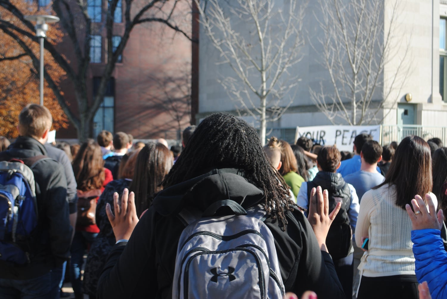 A protestor with her hands up in deference to the chant "Hands up, don't shoot." Protesters gathered from the Graduate School of Education and Harvard Law School in front of HLS on Monday at noon.