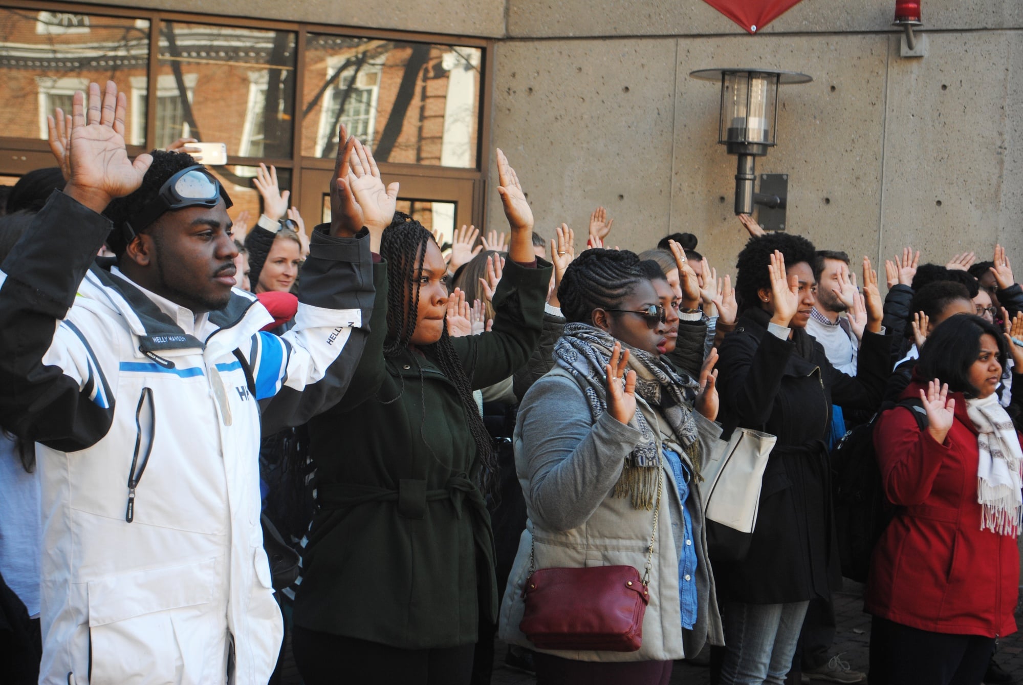 Protestors with their hands up in deference to the chant "Hands up, don't shoot." Students gathered from the Graduate School of Education and Harvard Law School to march from Gutmann Library to HLS on Monday at noon.