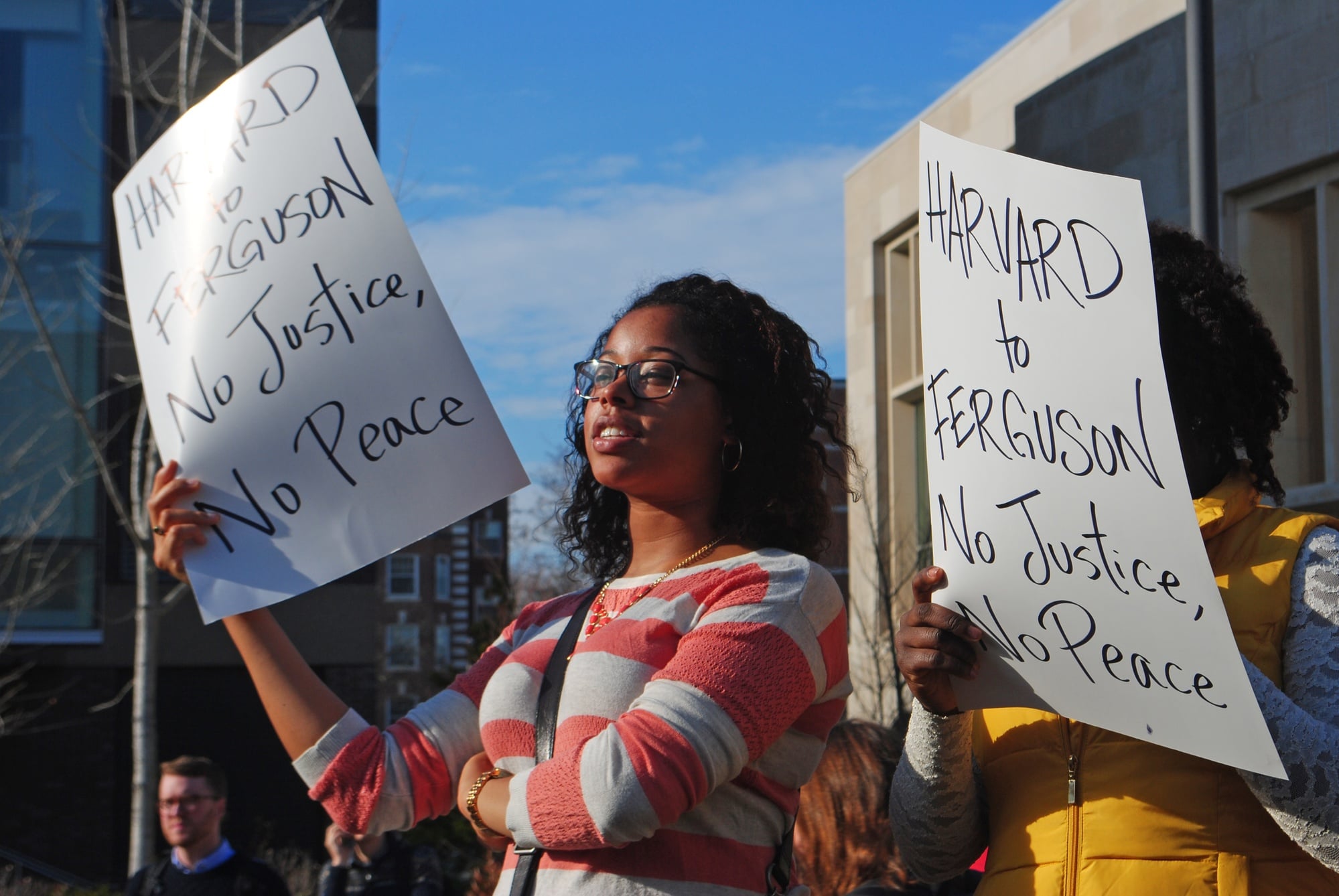 Michele Hall, a student at the Law School, holds a sign protesting the verdict in Ferguson, Mo. Protesters gathered from the Graduate School of Education and the Law School on Monday at noon.