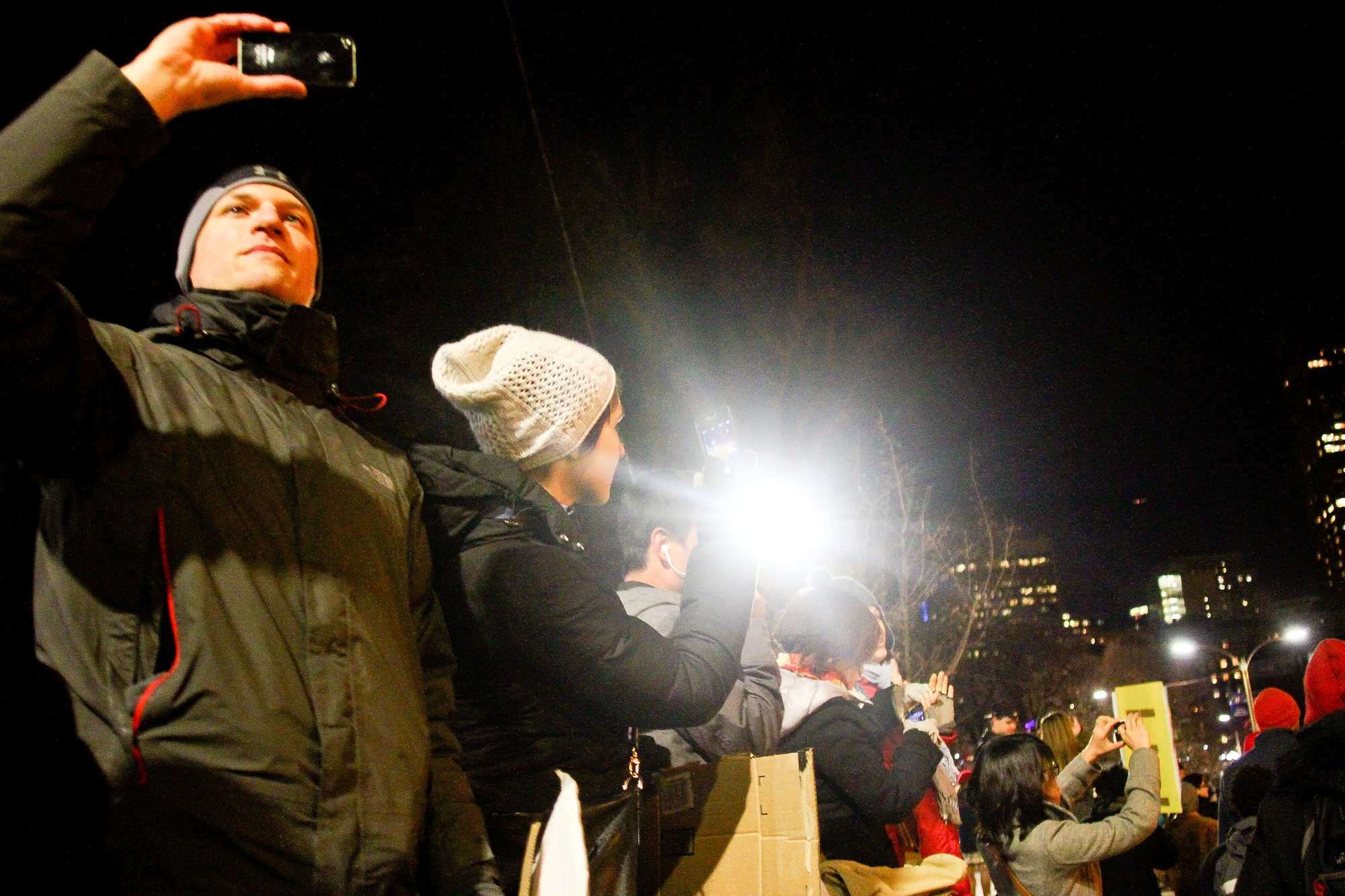 Bystanders photographing the protest.