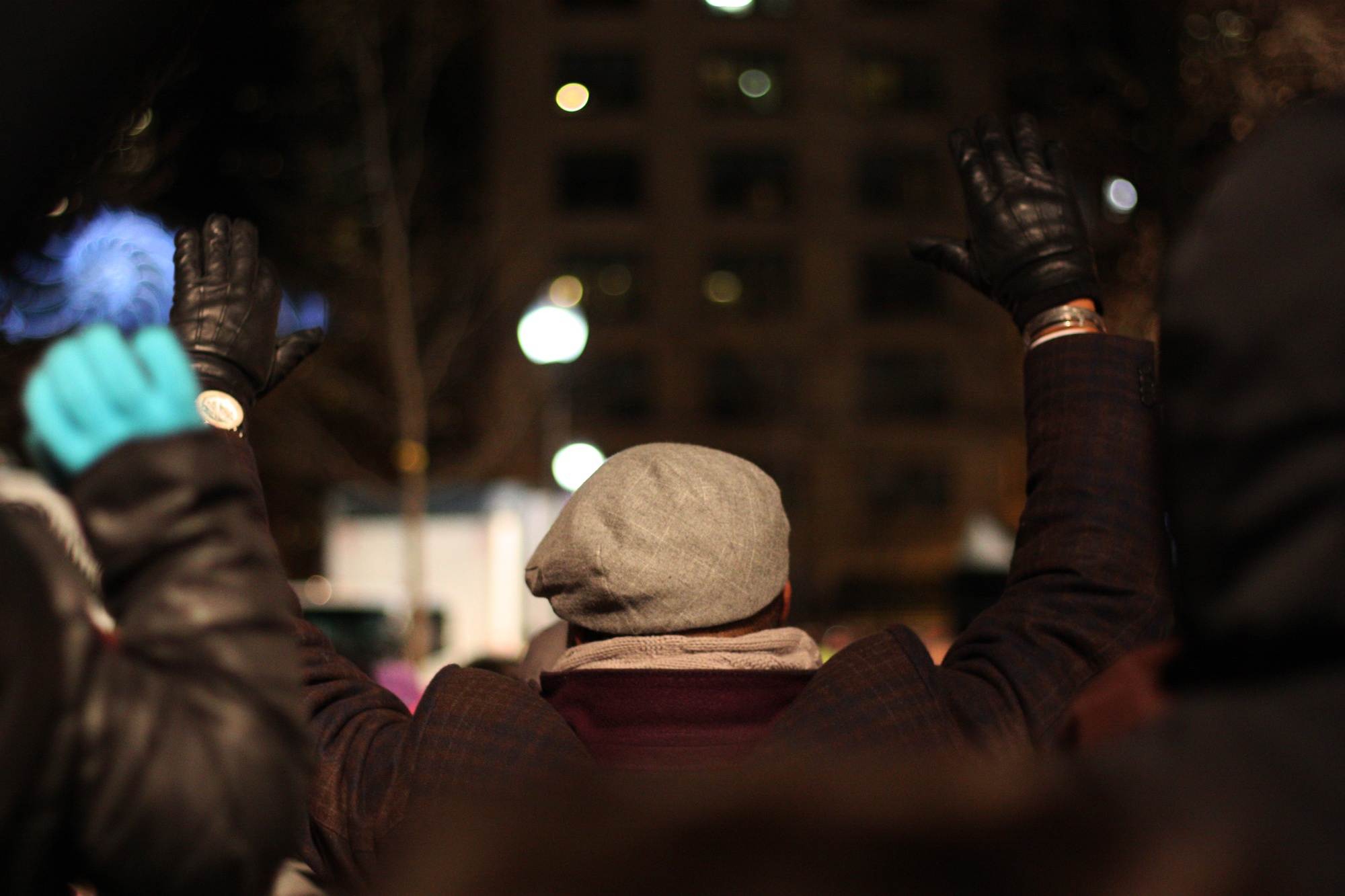 A demonstrator raises his hands as the crowd chants "hands up, don't shoot".