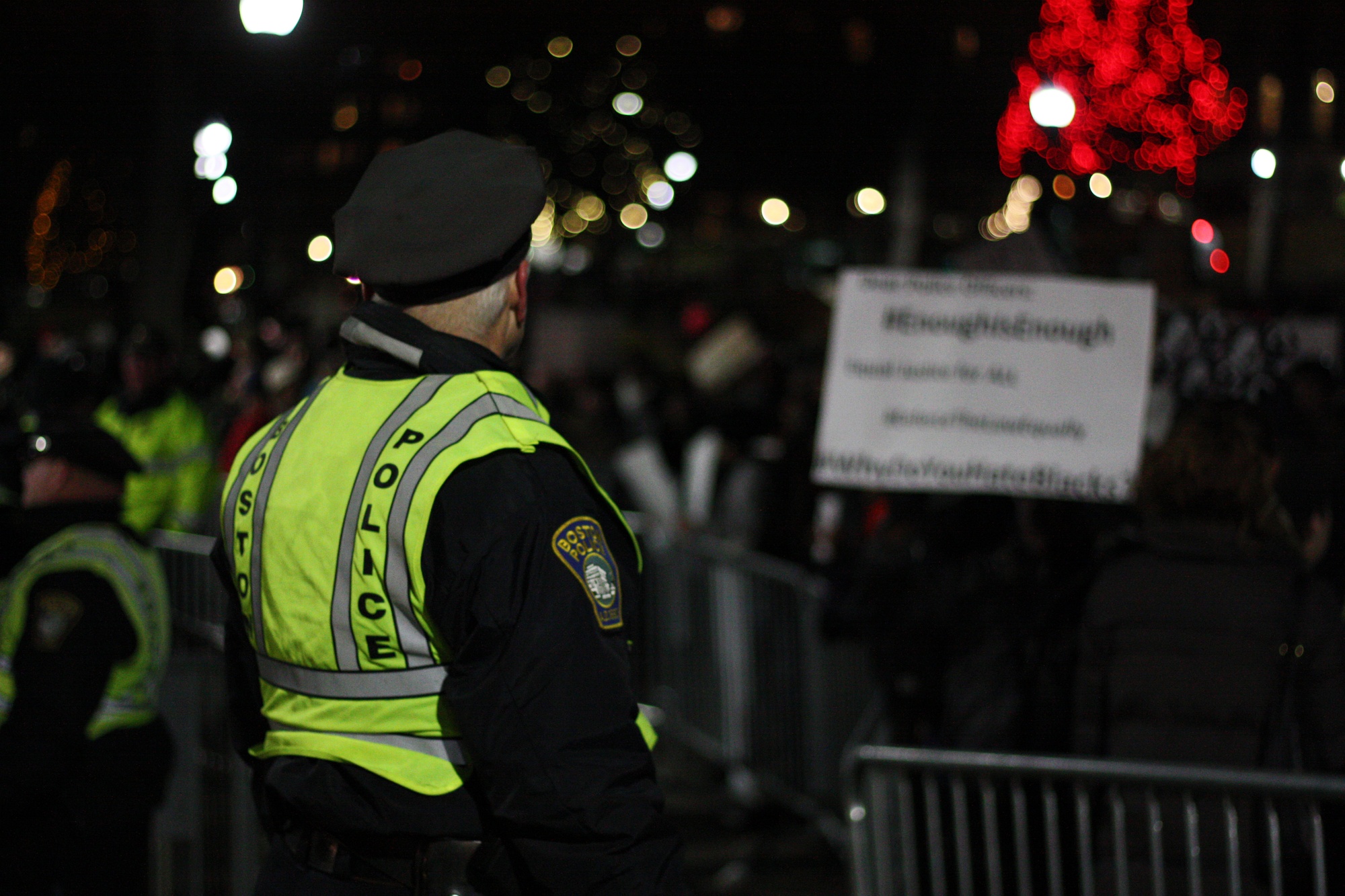 A Boston police officer looks on as protestors flood Boston Common on Thursday evening.