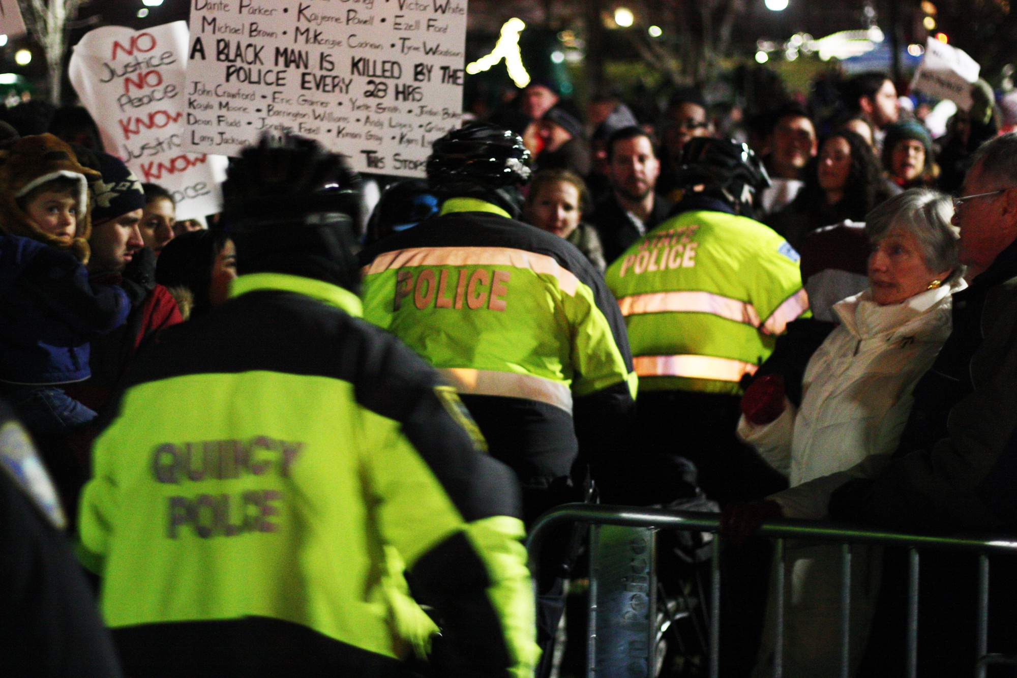 Police officers from a variety of departments across Boston push through the crowd amid chants from protestors.