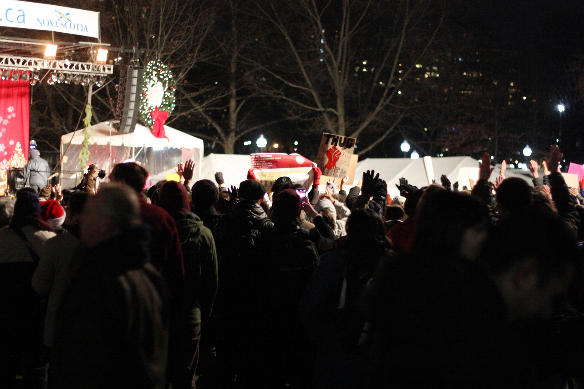 Protestors shout and chant during the performances at the tree lighting ceremony in Boston Common.