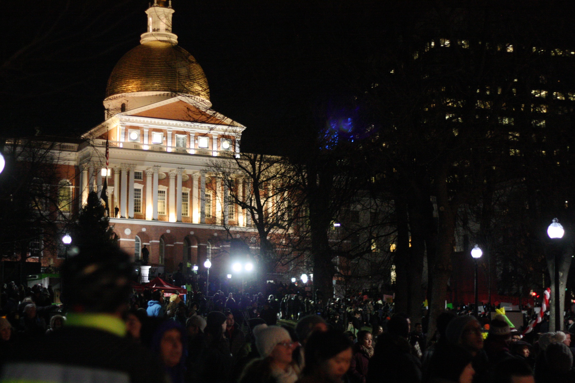 Demonstrators gather in front of the Massachusetts State House.