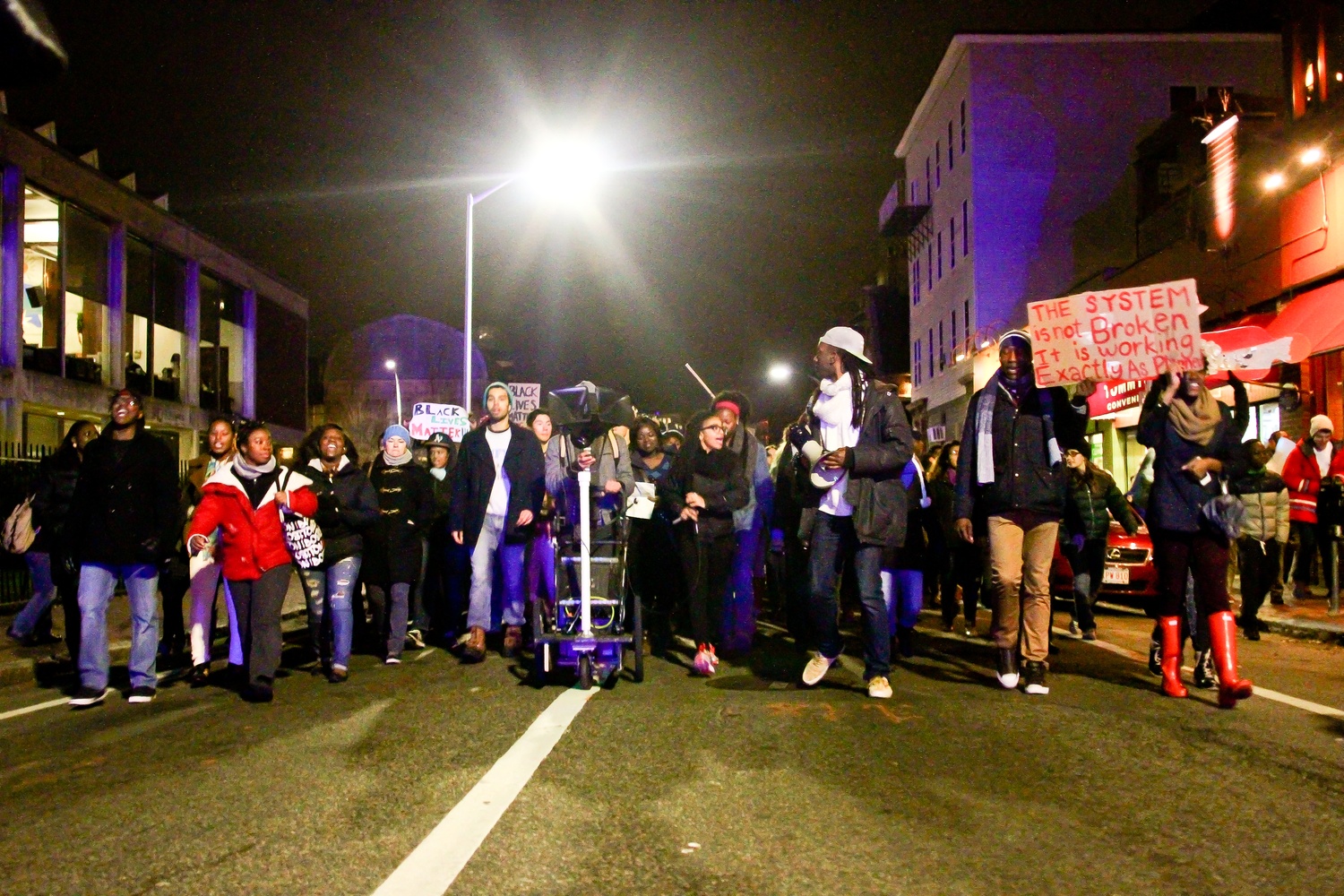 Protestors march down Mt. Auburn street towards Central Square.