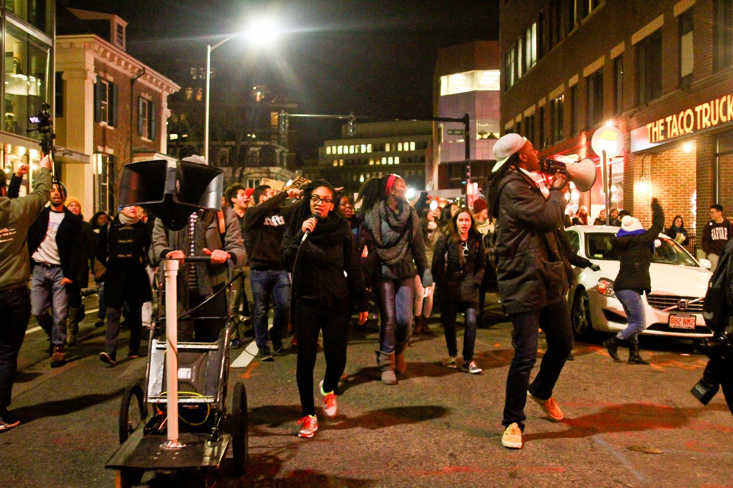 Protestors march down Mt. Auburn street towards Central Square.