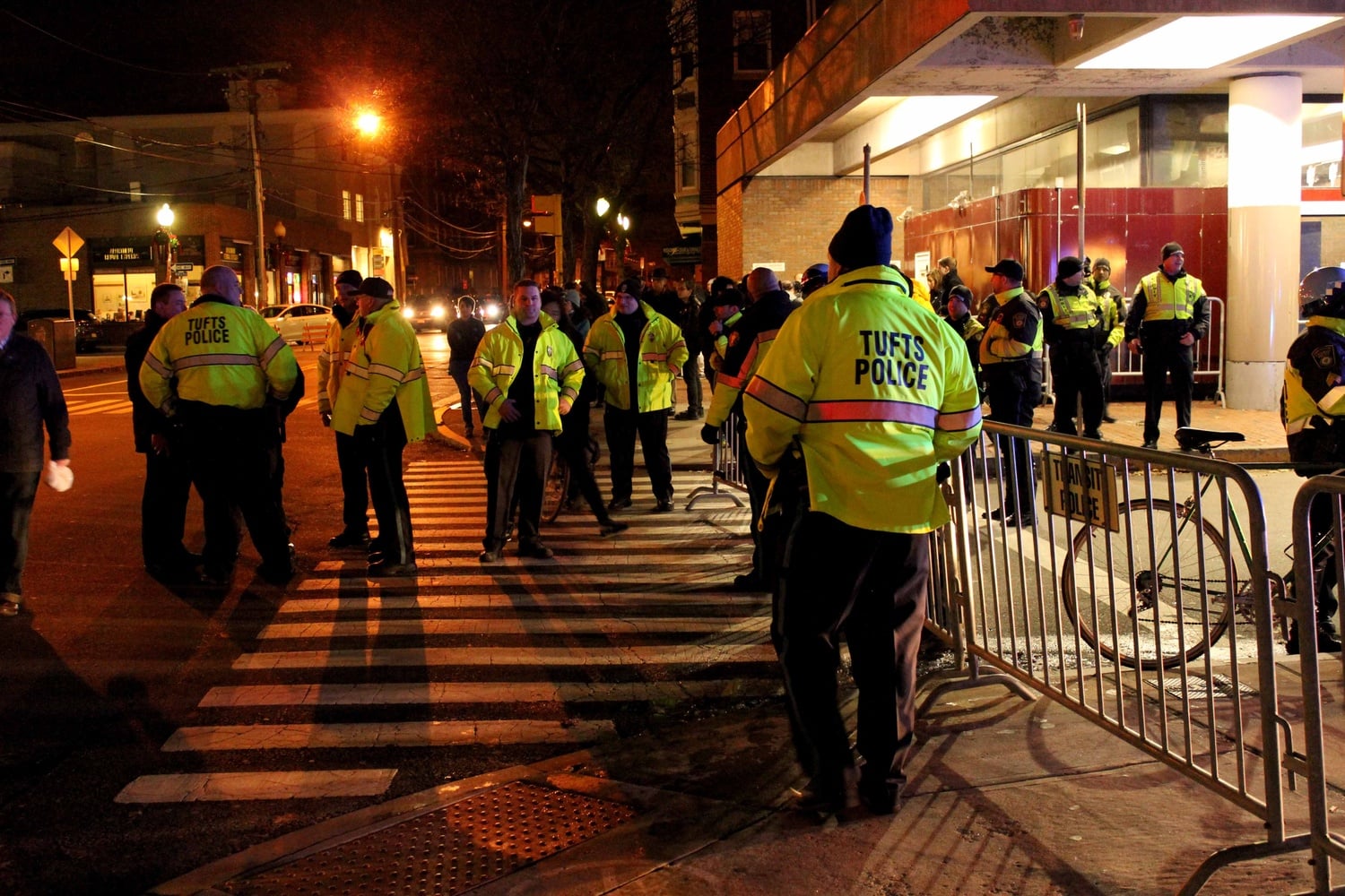 Tufts Police stand near the Davis Square T Station on Friday evening during protests of the recent non-indictments of the officers in the Michael Brown and Eric Garner cases. Protestors began in Davis Square and continued to MIT, laying down at key transportation sites.