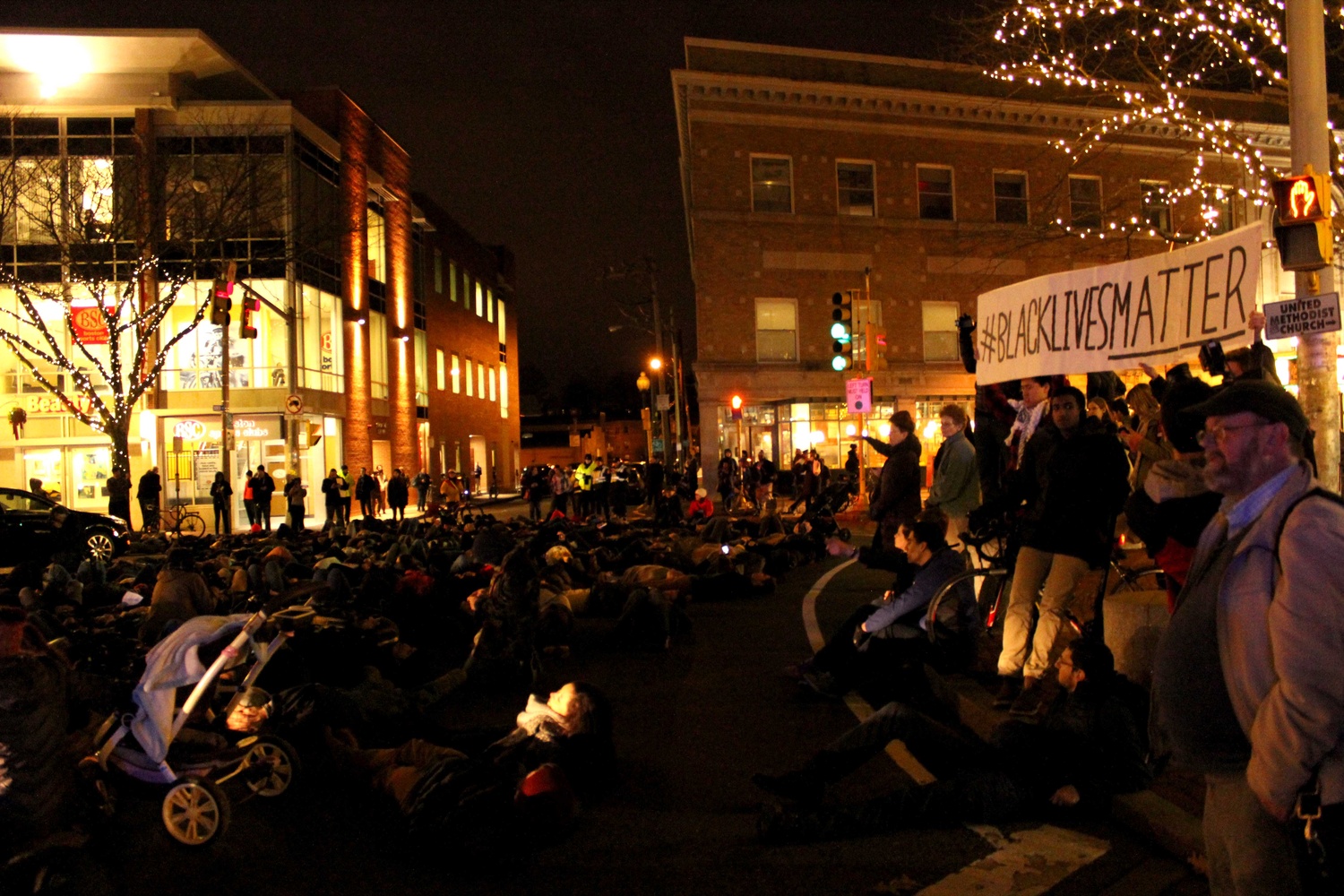 Protestors lay down during a "die-in" in Davis Square on Friday evening to protest the recent non-indictments of the officers in the Michael Brown and Eric Garner cases. Protestors began in Davis Square and continued to MIT, laying down at key transportation sites.
