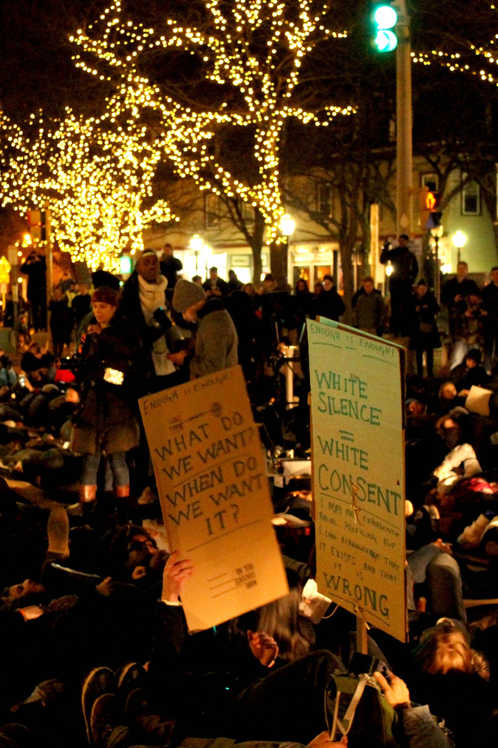Protestors lay down during a "die-in" in Davis Square on Friday evening to protest the recent non-indictments of the officers in the Michael Brown and Eric Garner cases. Protestors began in Davis Square and continued to MIT, laying down at key transportation sites.