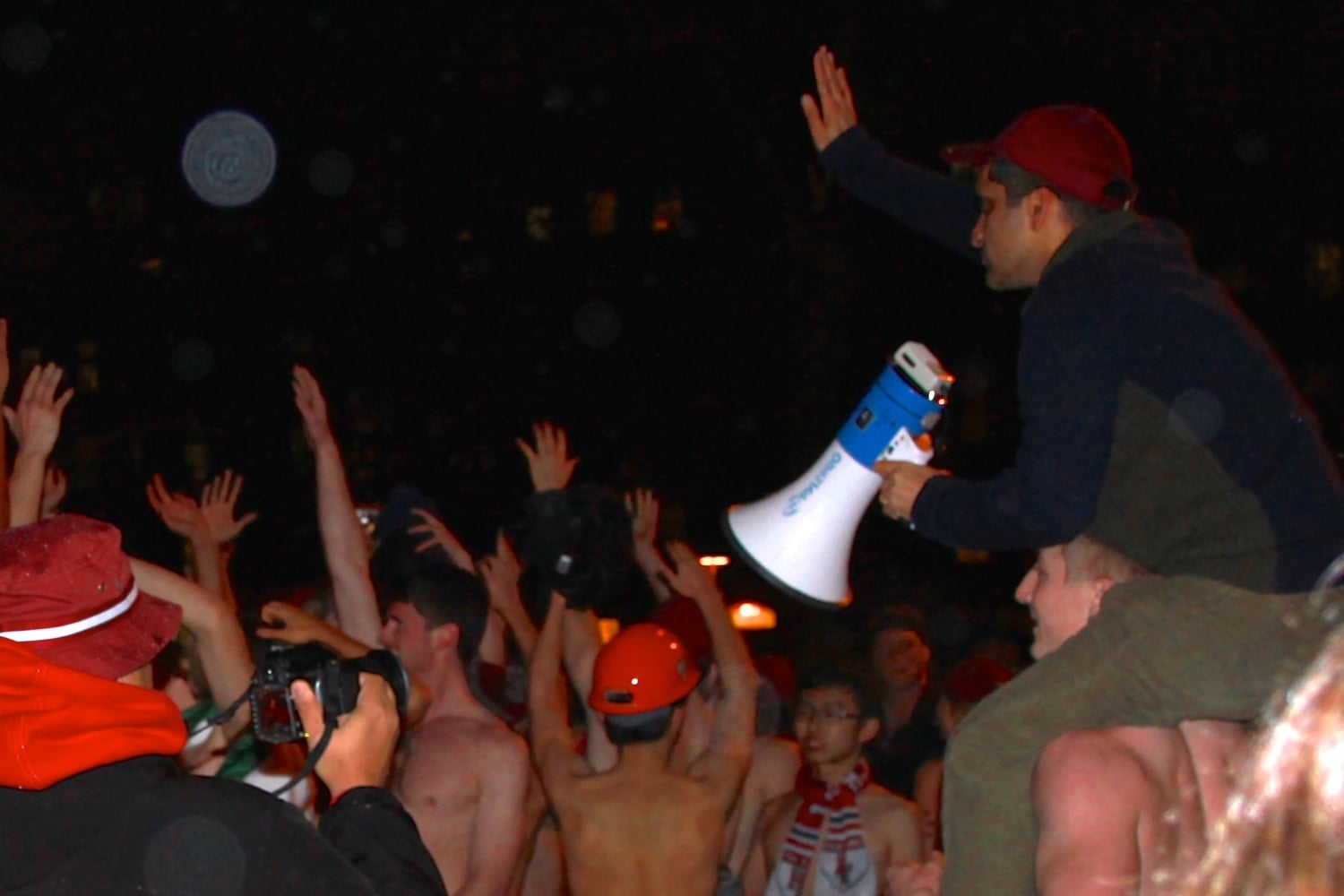 Dean of College Rakesh Khurana attempts to gain the attention of the participants of Primal Scream by climbing onto the shoulders of a Primal Scream runner in December in Harvard Yard. Other students organized a protest, in response to recent grand jury non-indictments, that attempted to delay the start of the run.