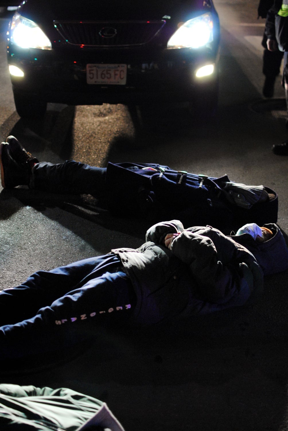 Harvard students lay in front of traffic during a die-in at the intersection of Memorial Dr. and Western Ave. in December to protest two recent, separate grand jury decisions not to indict white police officers who killed two unarmed black men.