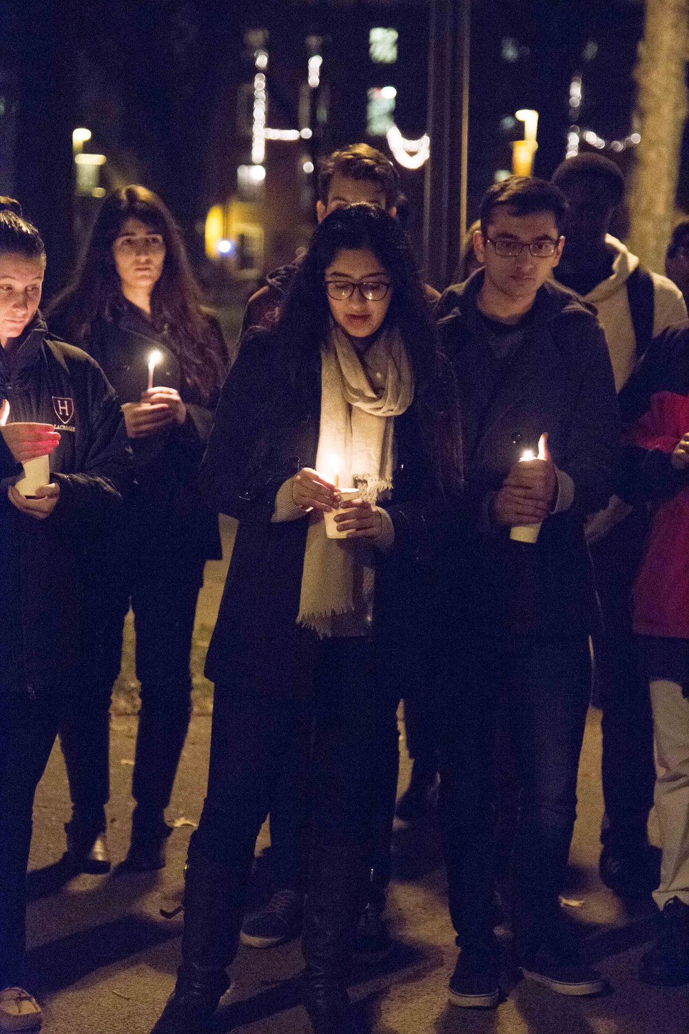 Members of the Harvard community hold candles on Tuesday evening during a vigil at the John Harvard Statue for the 141 people killed by militants from the Pakistani Taliban at an army-run school earlier that day.  Member of the Pakistani Students Association, which hosted the vigil, and Pakistani native Manhoor F. Khan ‘17 explained that she is grateful for the support of attendees “because after a certain point things like this eventually become routine at home.”  