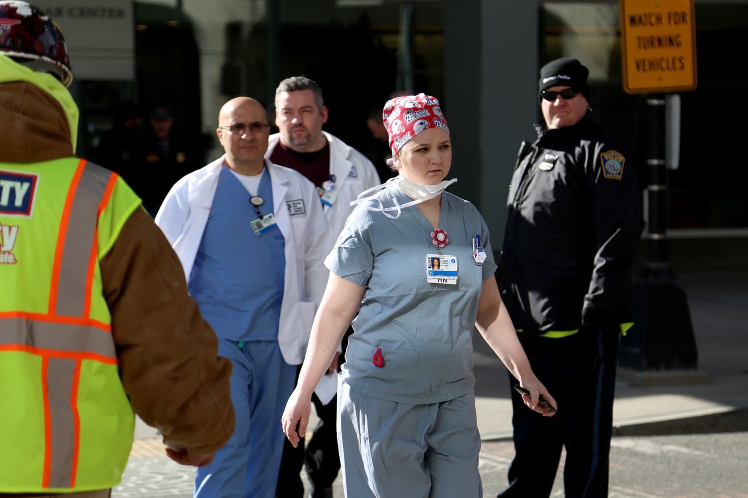 Brigham and Women's hospital personnel cross Francis Street outside the Shapiro building where Harvard Medical School assistant professor Michael J. Davidson was shot Tuesday morning.